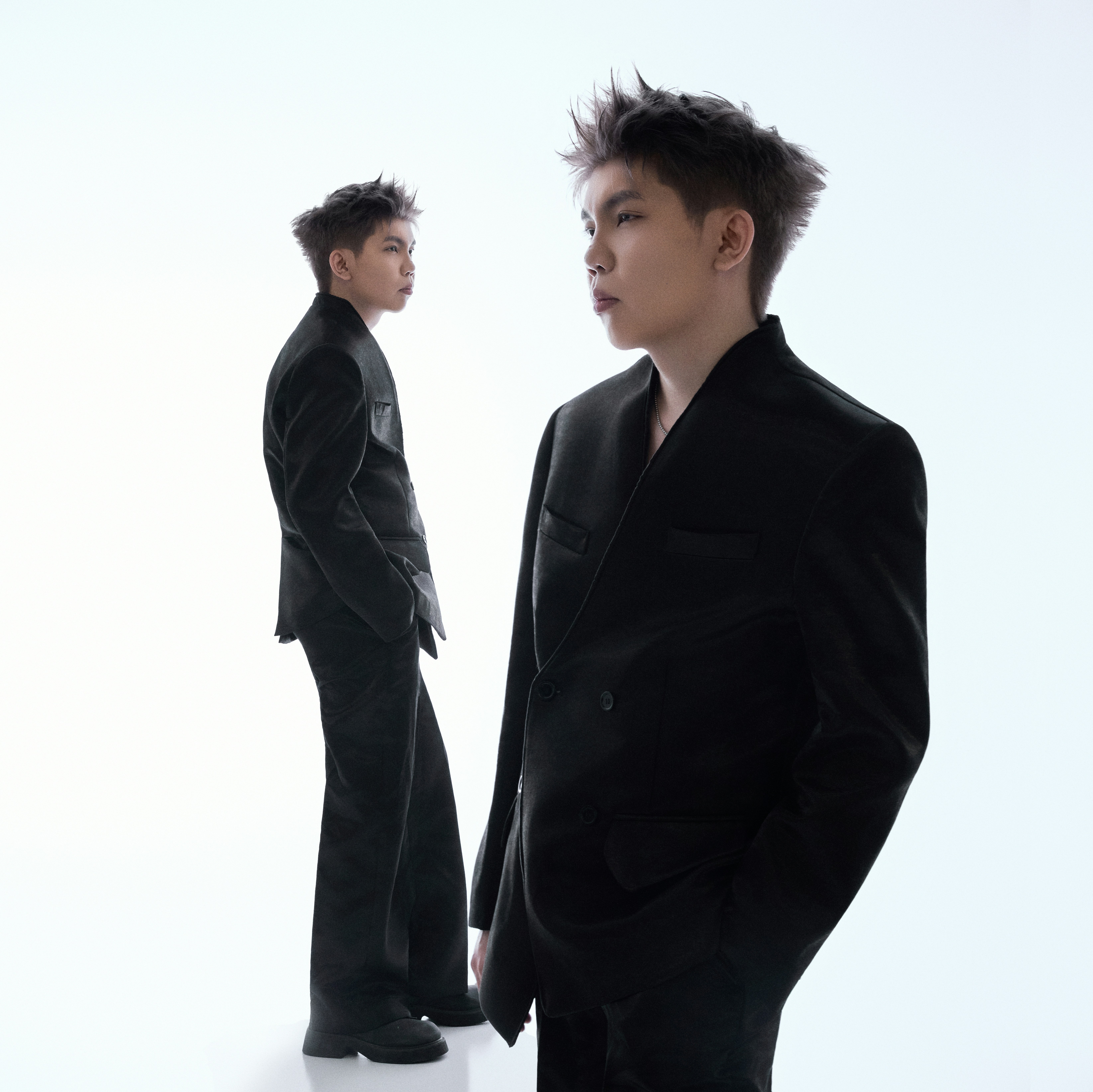 Two men in black suits against a white background