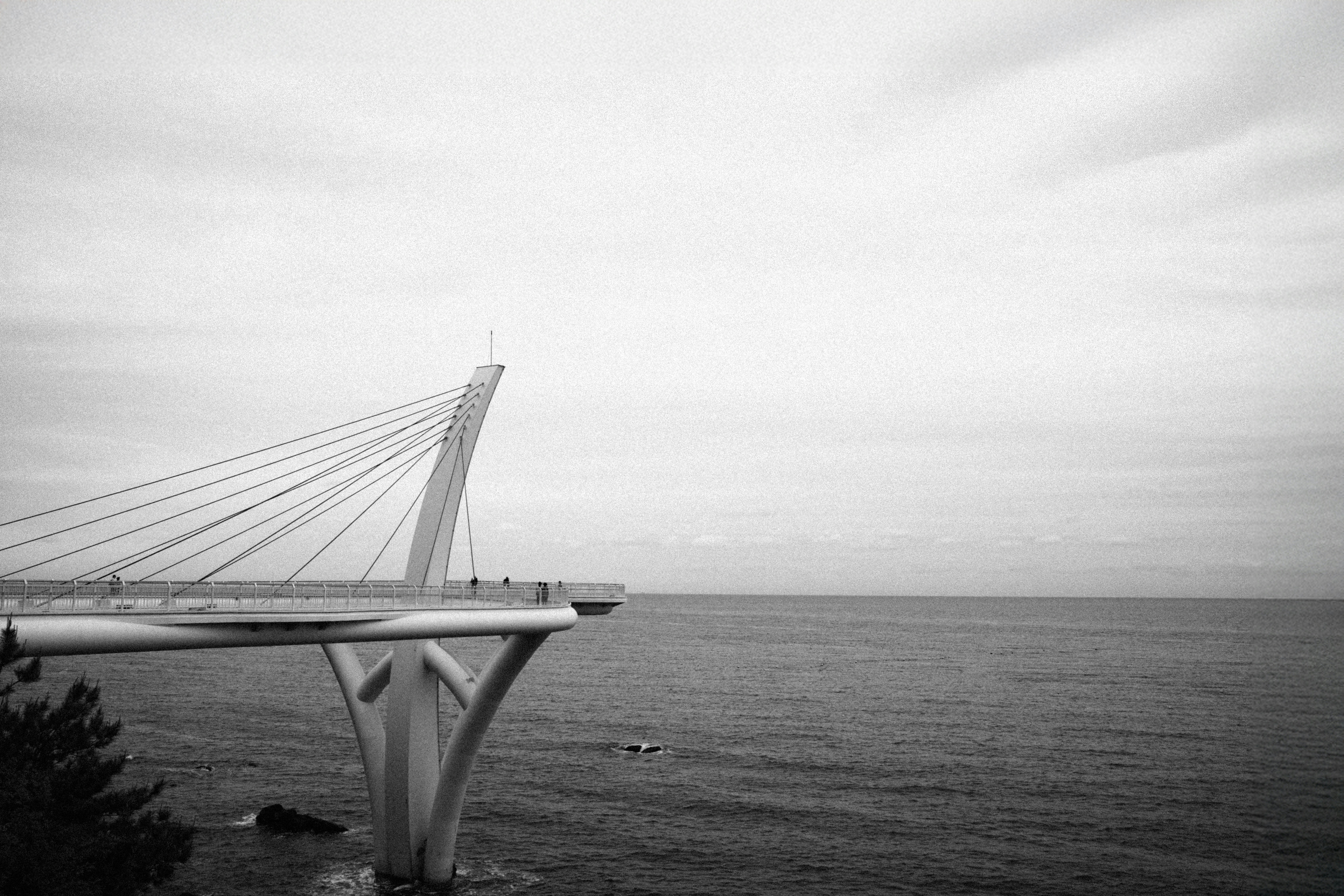 Modern bridge over the ocean under cloudy sky