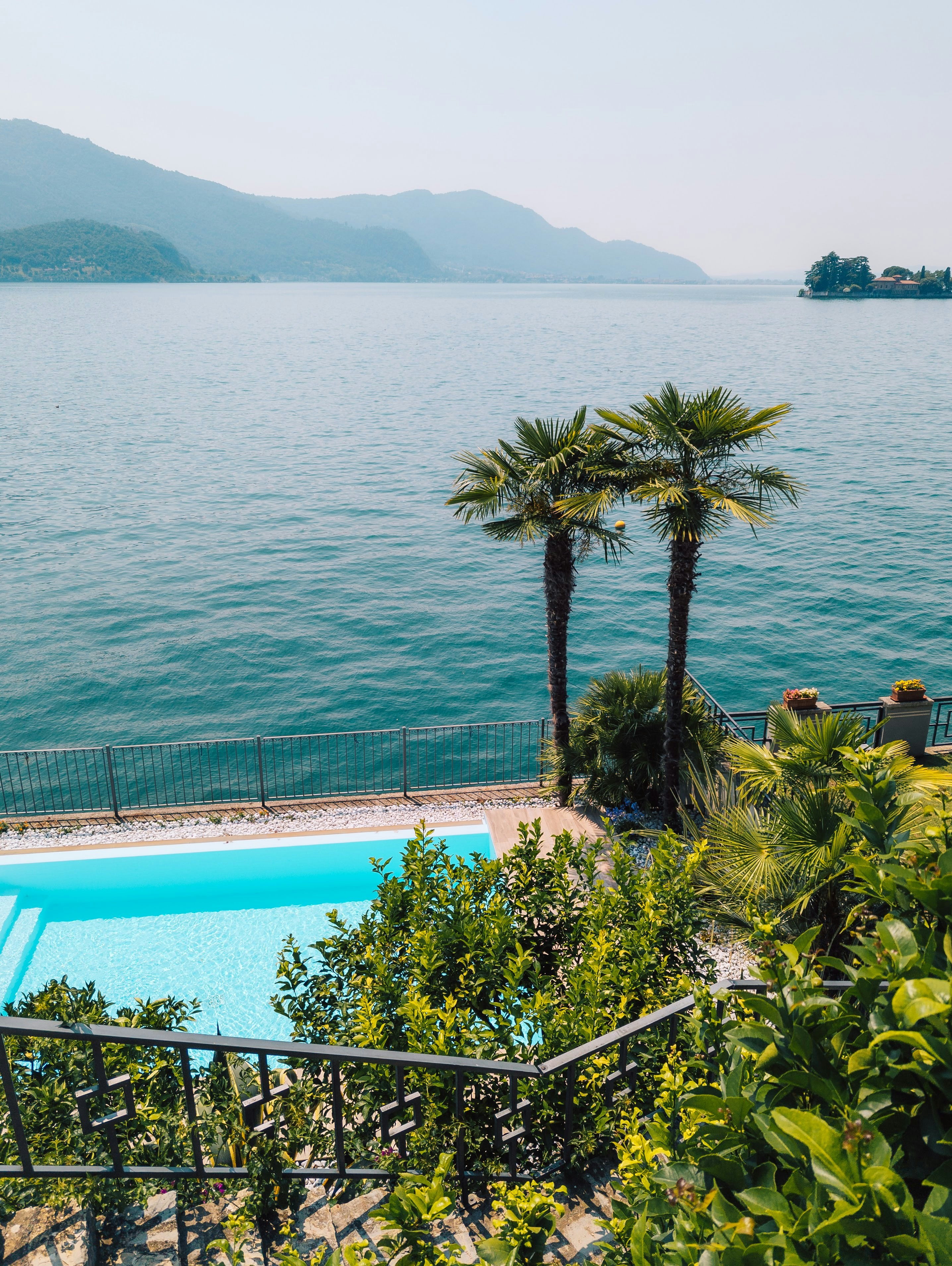 Palm trees and pool overlook a large blue lake.