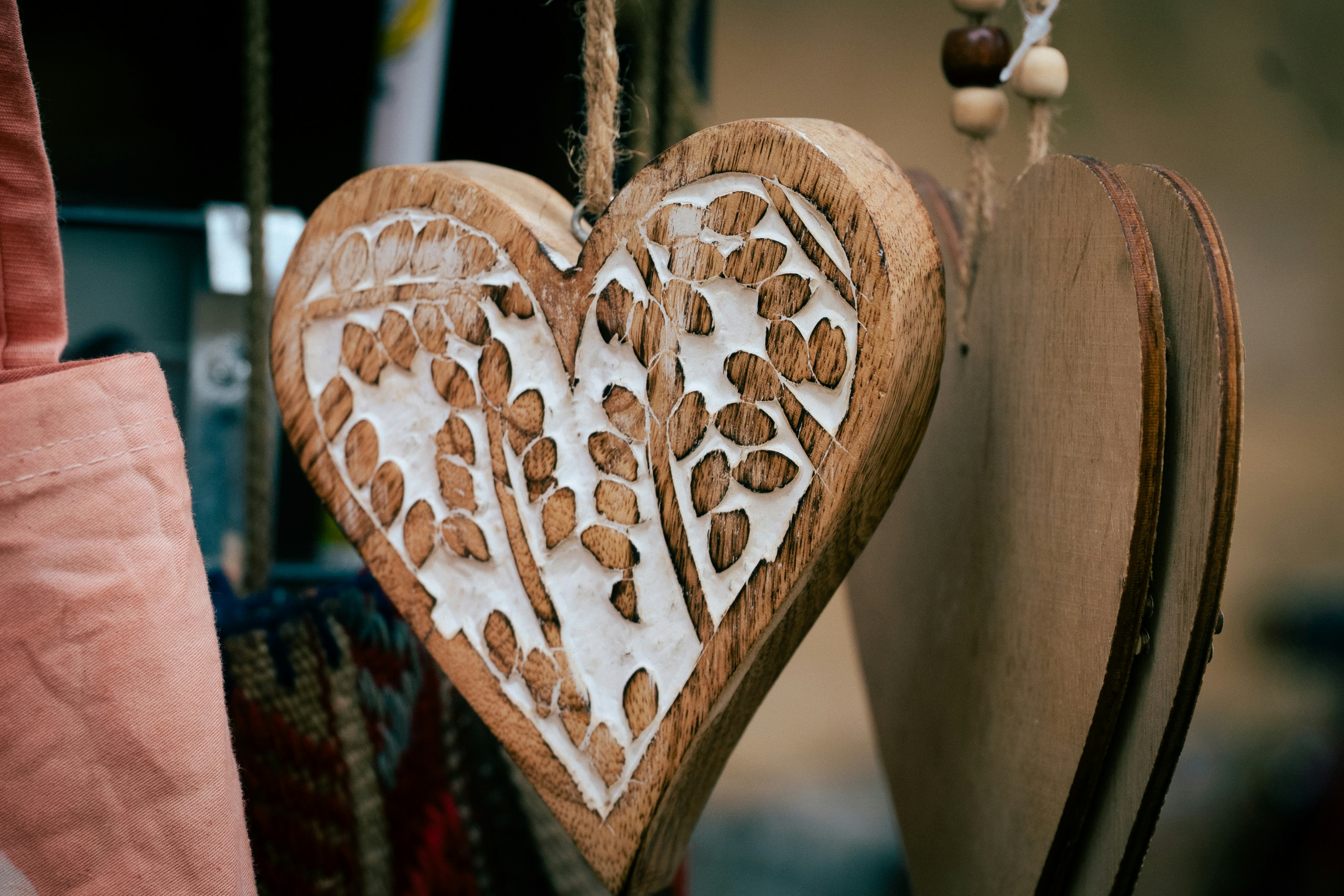 Ornement en cœur en bois sculpté avec un motif floral complexe.