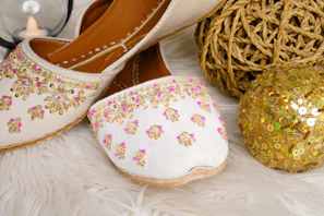 Embroidered white shoes with gold and pink accents