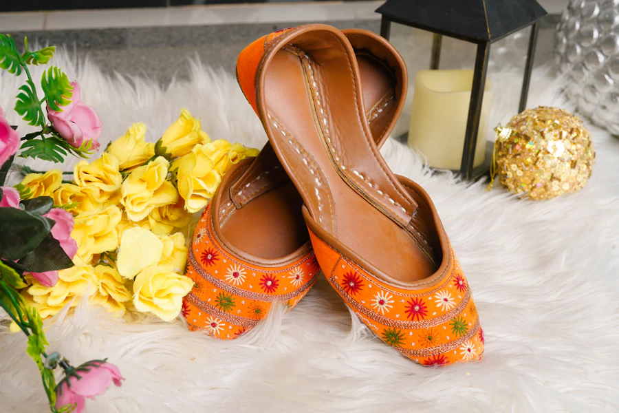 Men's embroidered orange Punjabi jutti shoes with floral patterns