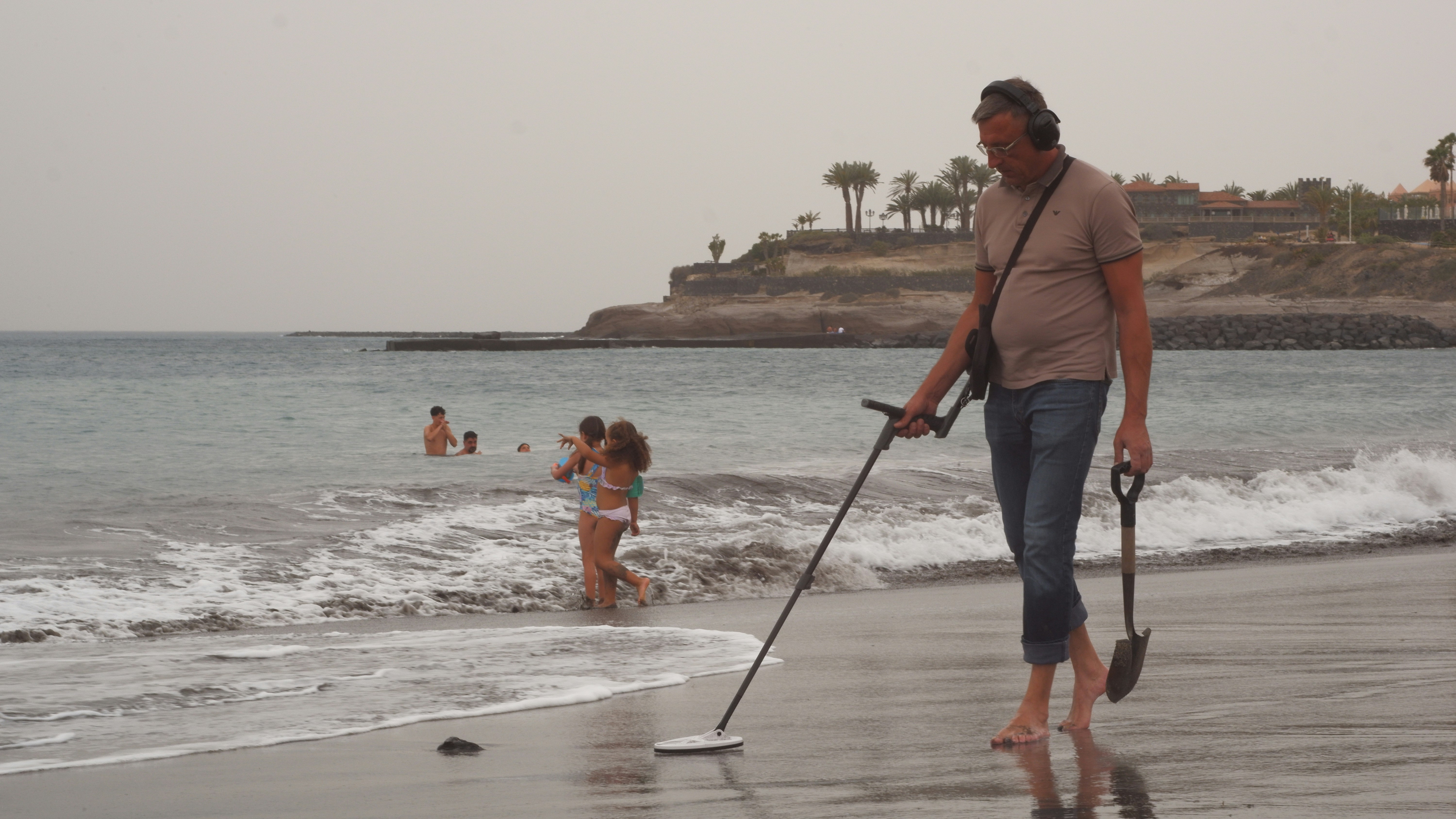 Man with metal detector on a beach
