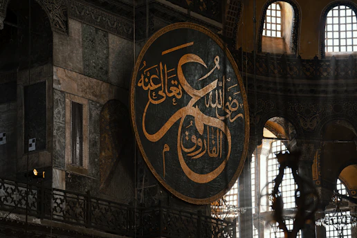 Large arabic calligraphy circle inside a grand building.