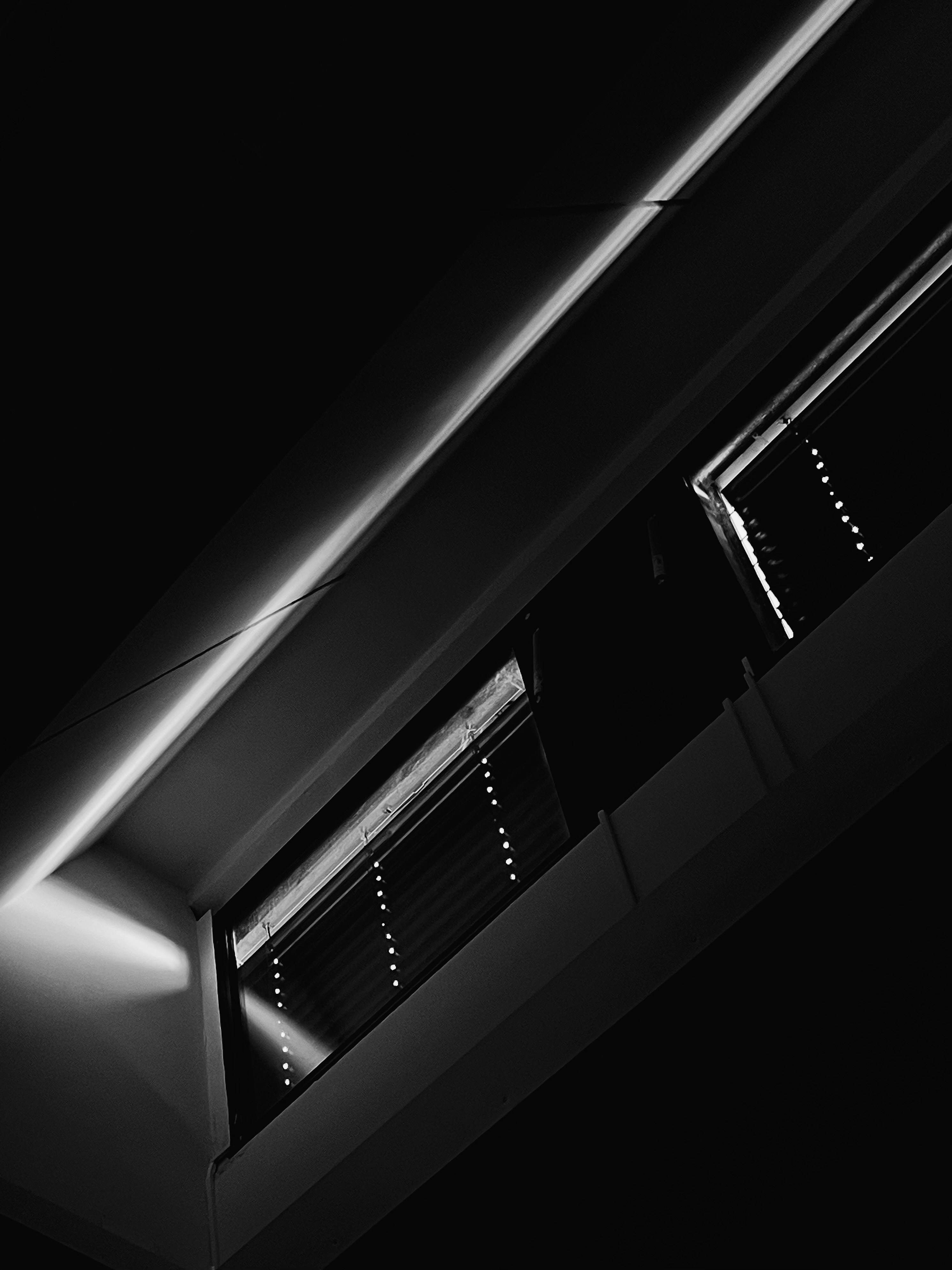 Diagonaler Lichtstrahl über dunkle Jalousien
