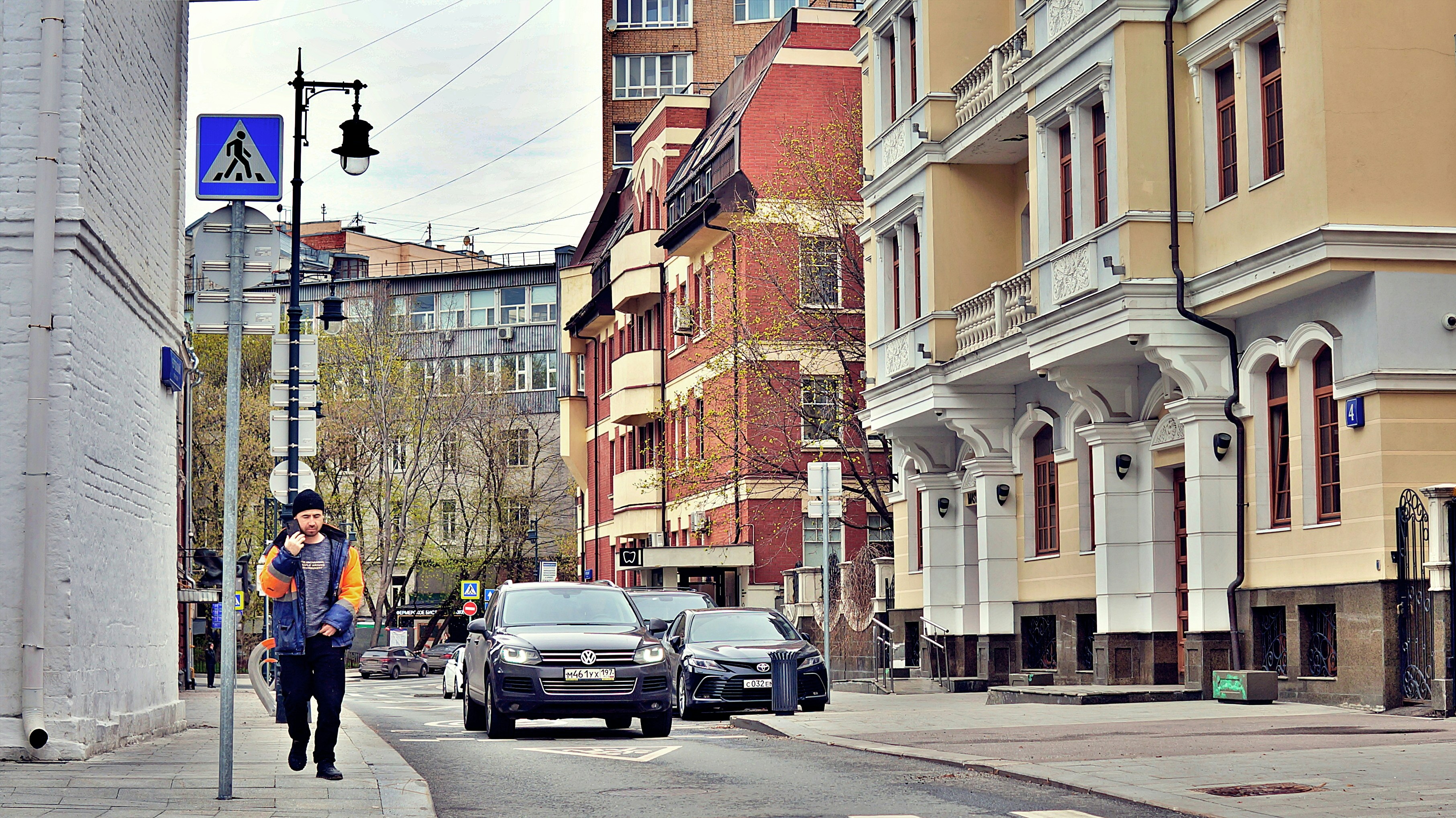 Man walking on street with cars and buildings