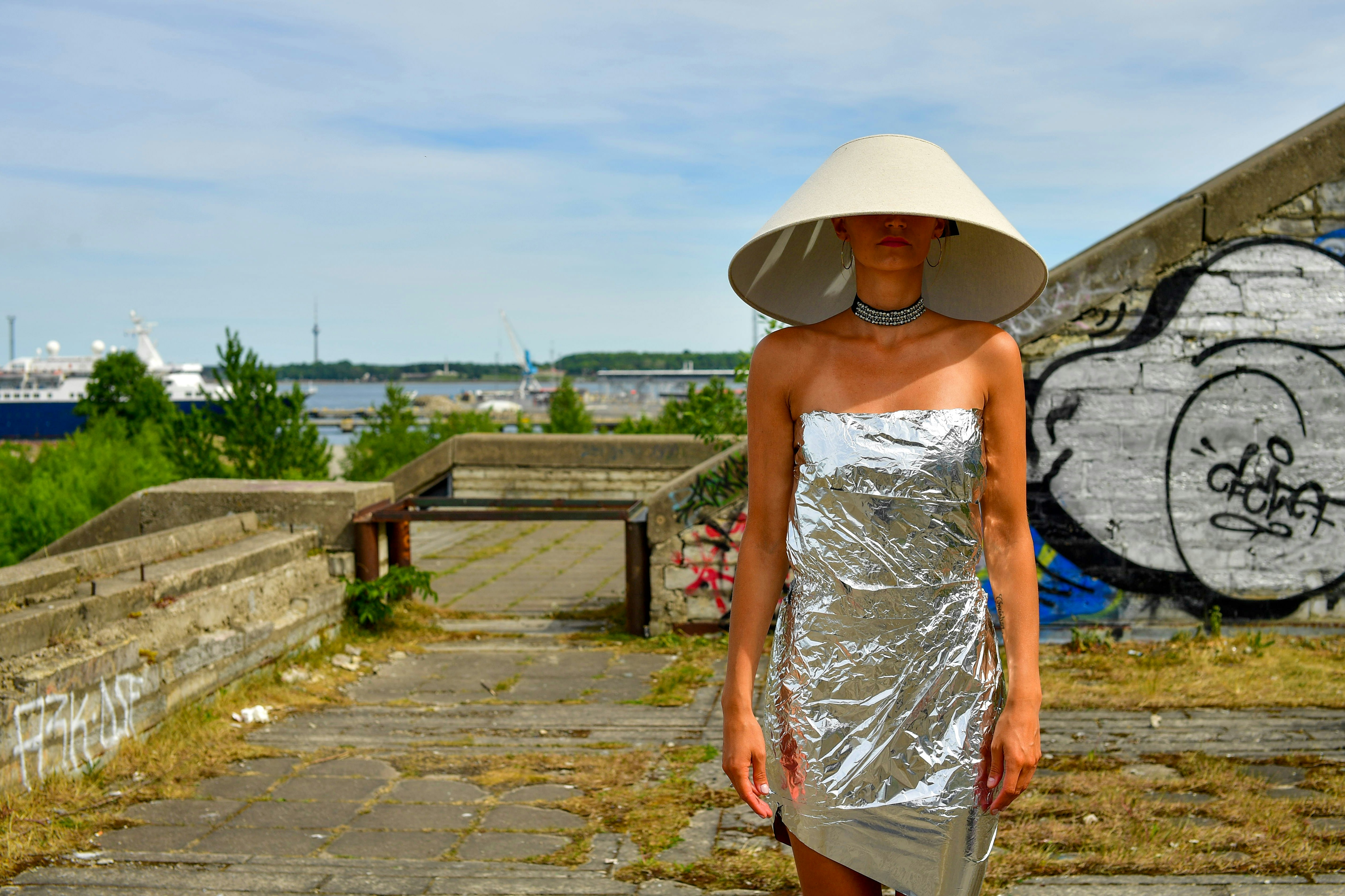Woman in avant-garde silver dress and lampshade hat