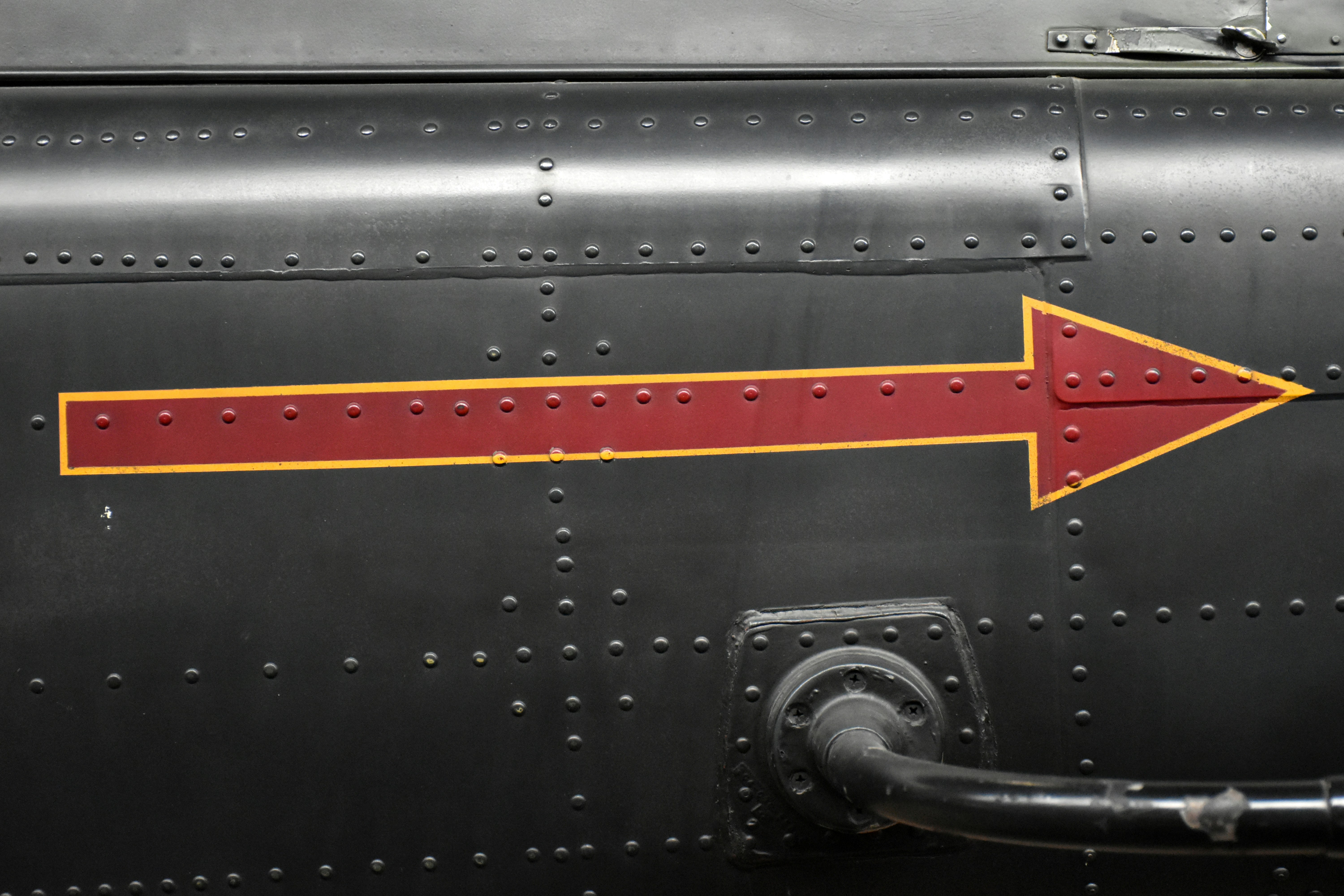 Red arrow pointing right on dark textured surface.