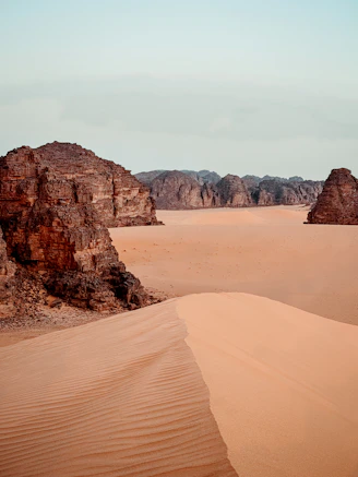 Vast desert landscape with sand dunes and rock formations admer tour Djanet Algeria