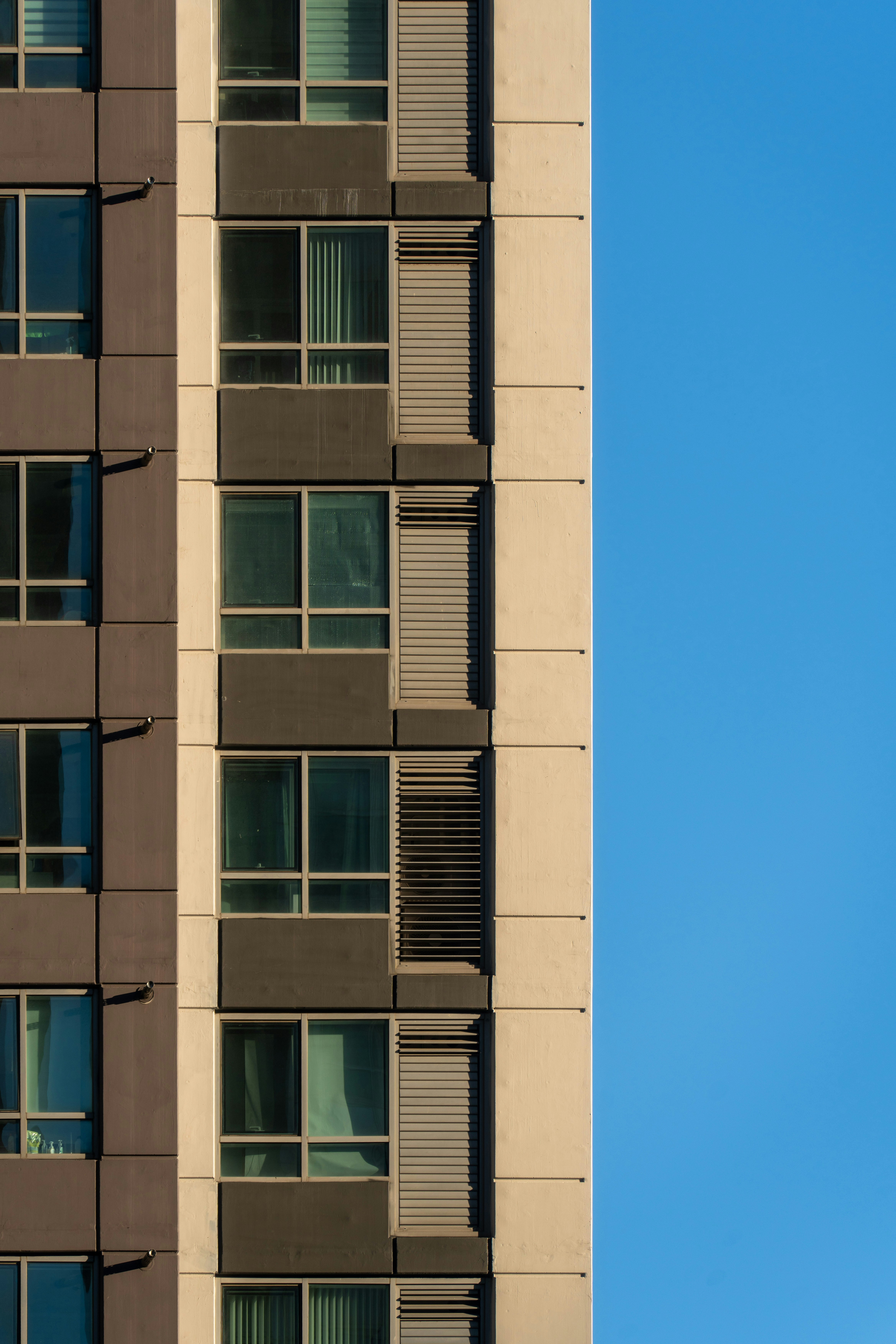 青空を背景に窓のある現代的な建物のファサード