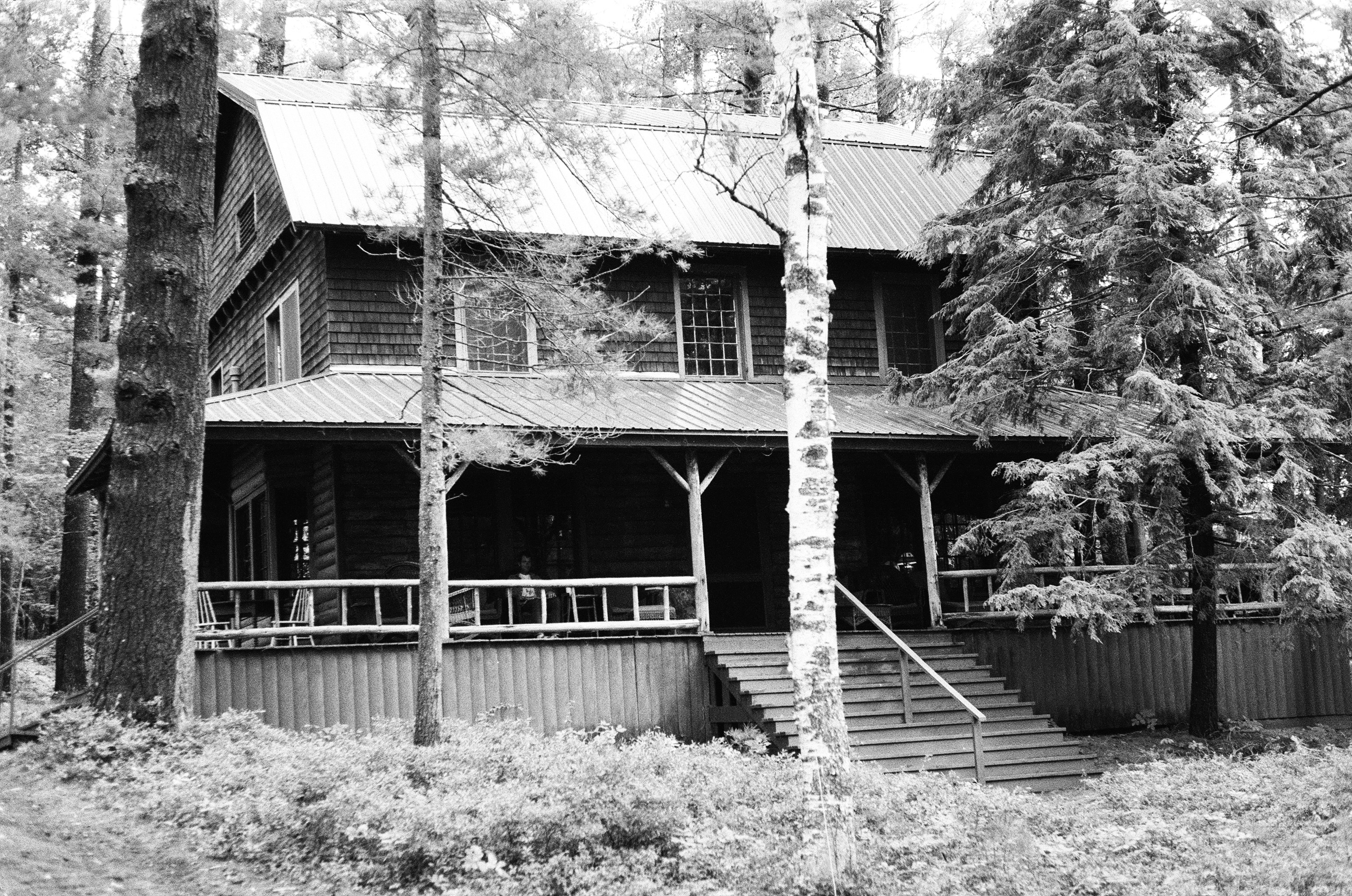 Wooden house with porch surrounded by trees