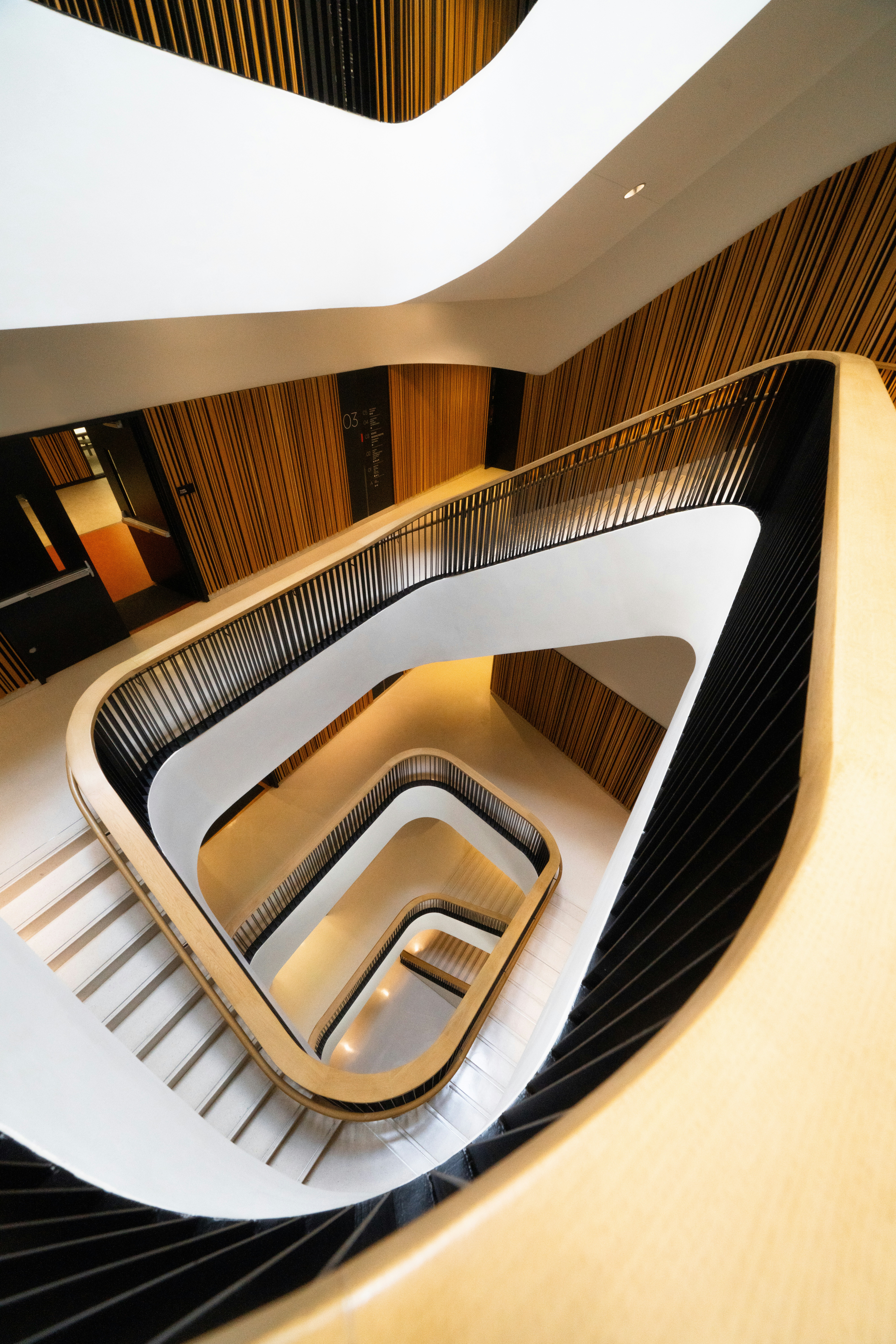 Modern spiral staircase with wooden accents and white railings