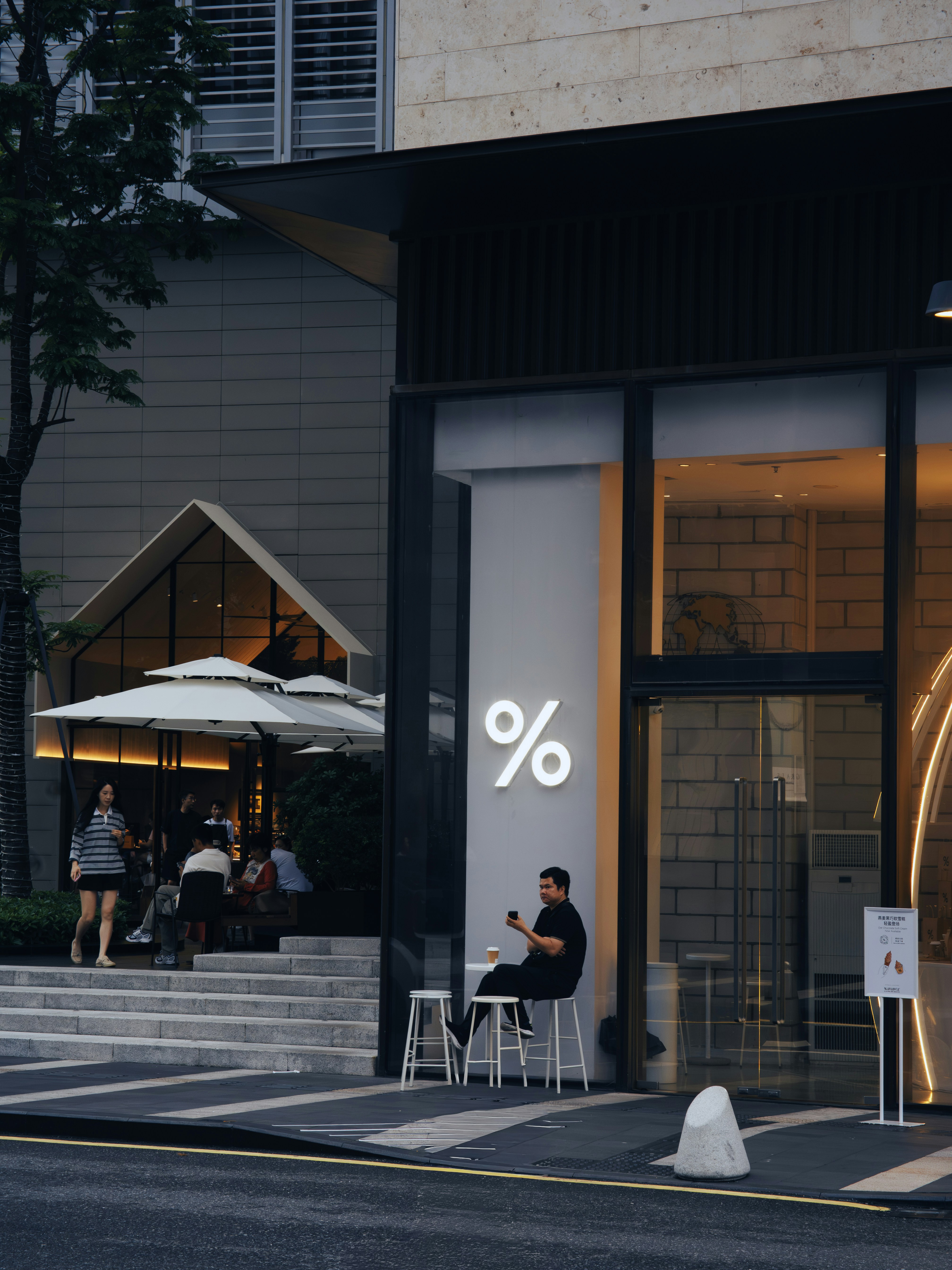 Man sitting outside a modern coffee shop
