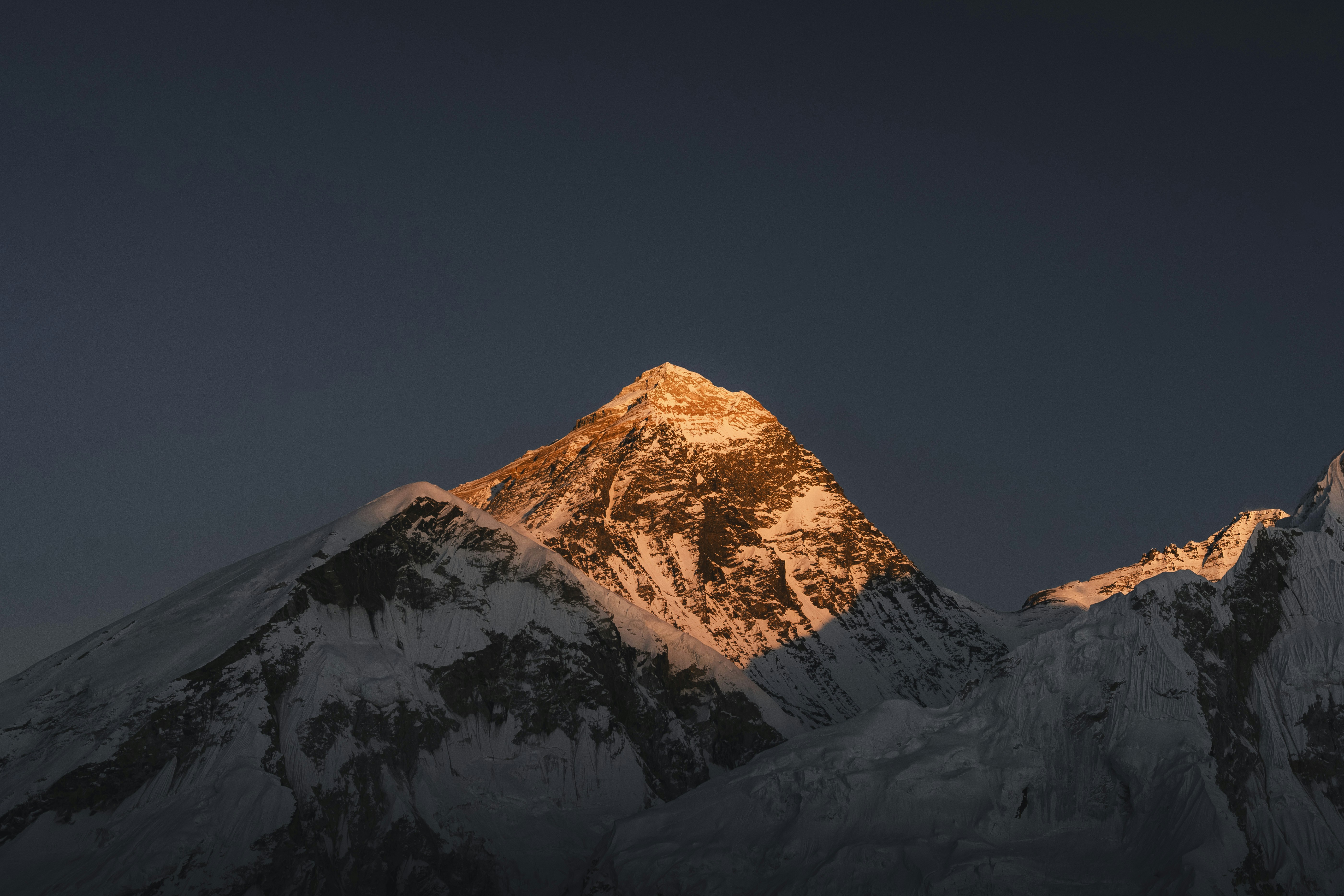Mount everest illuminated by golden sunrise light at sunrise.