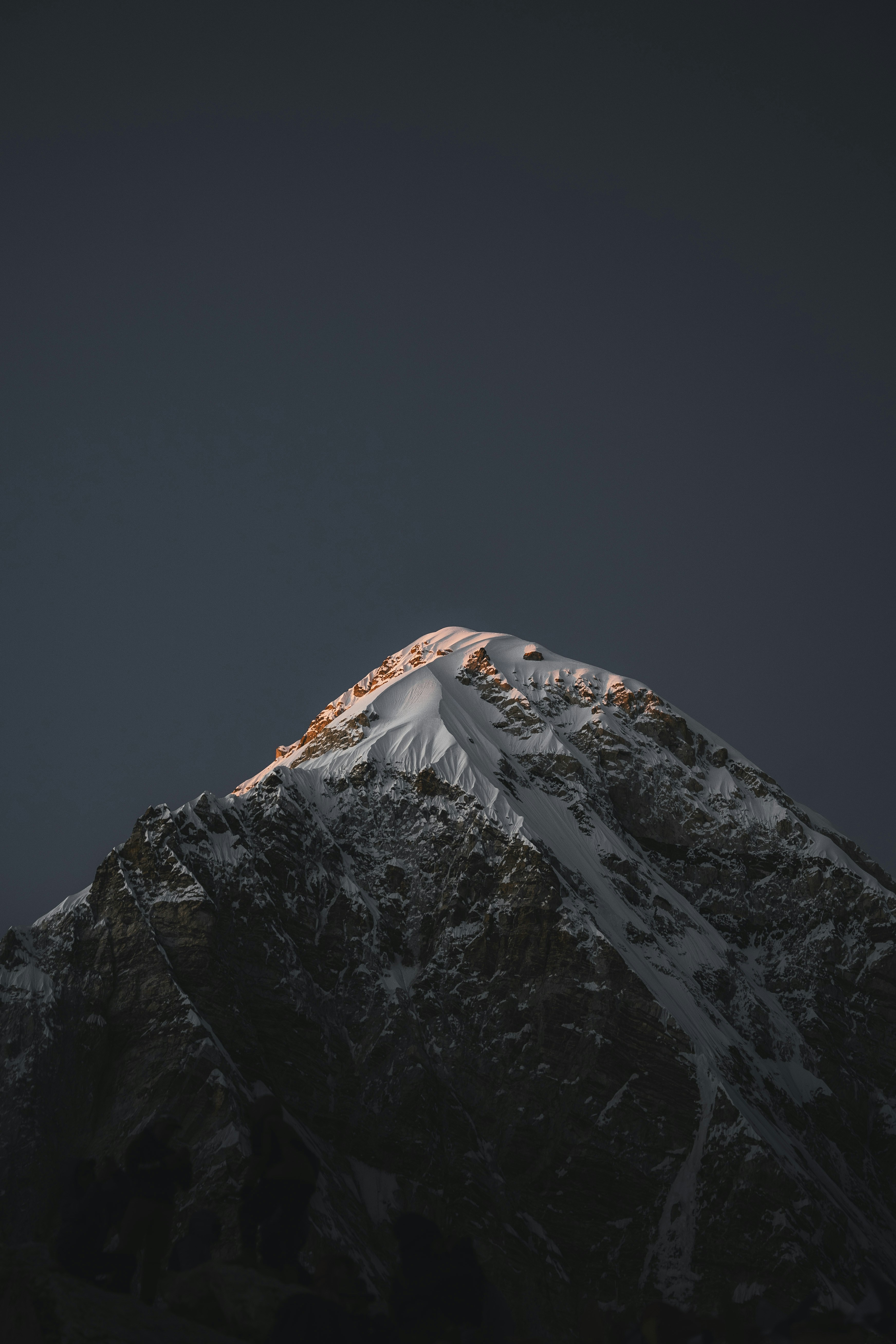 Cima innevata illuminata dalla luce dorata del sole