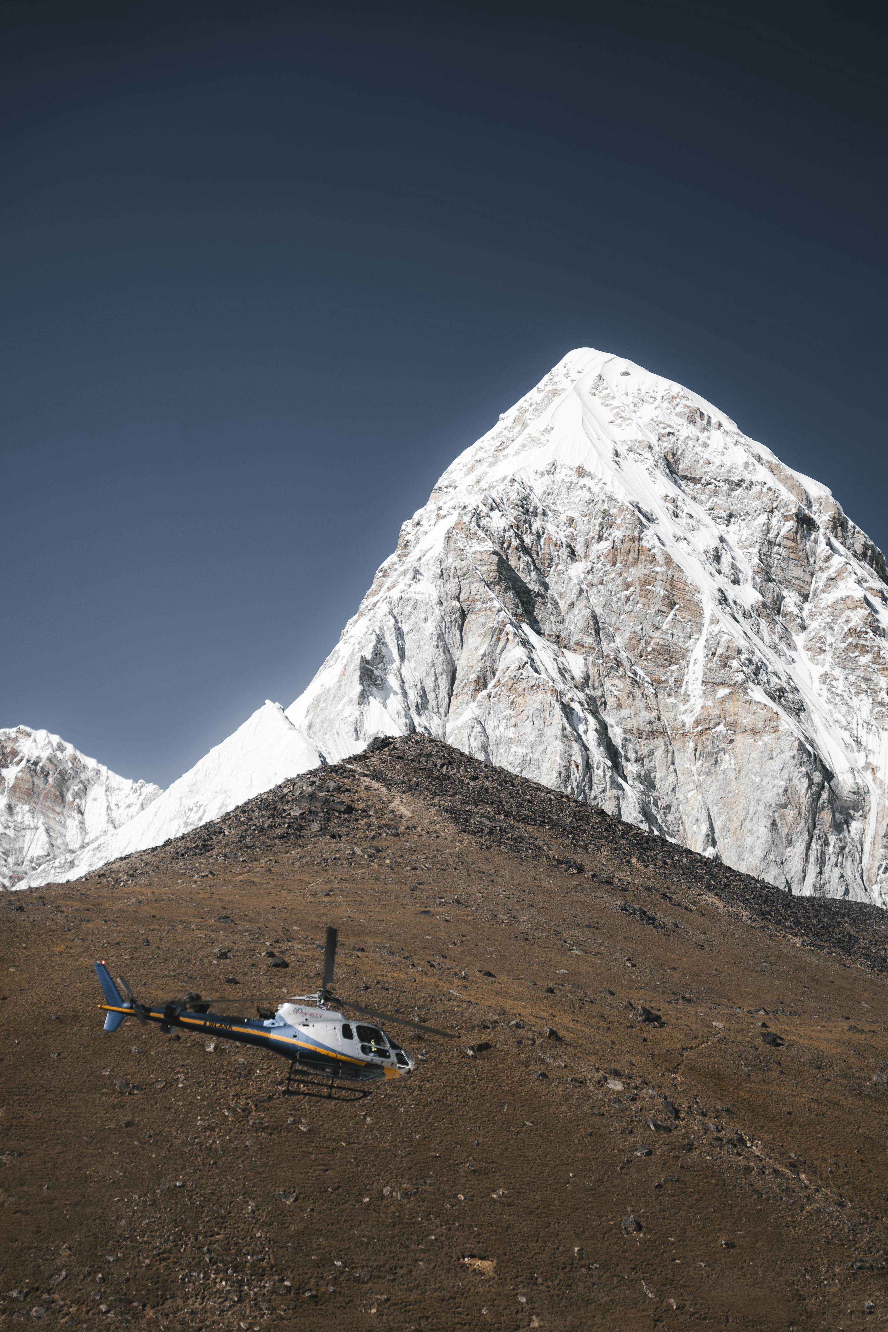 L'elicottero atterra su un pendio di montagna rocciosa vicino alla vetta.