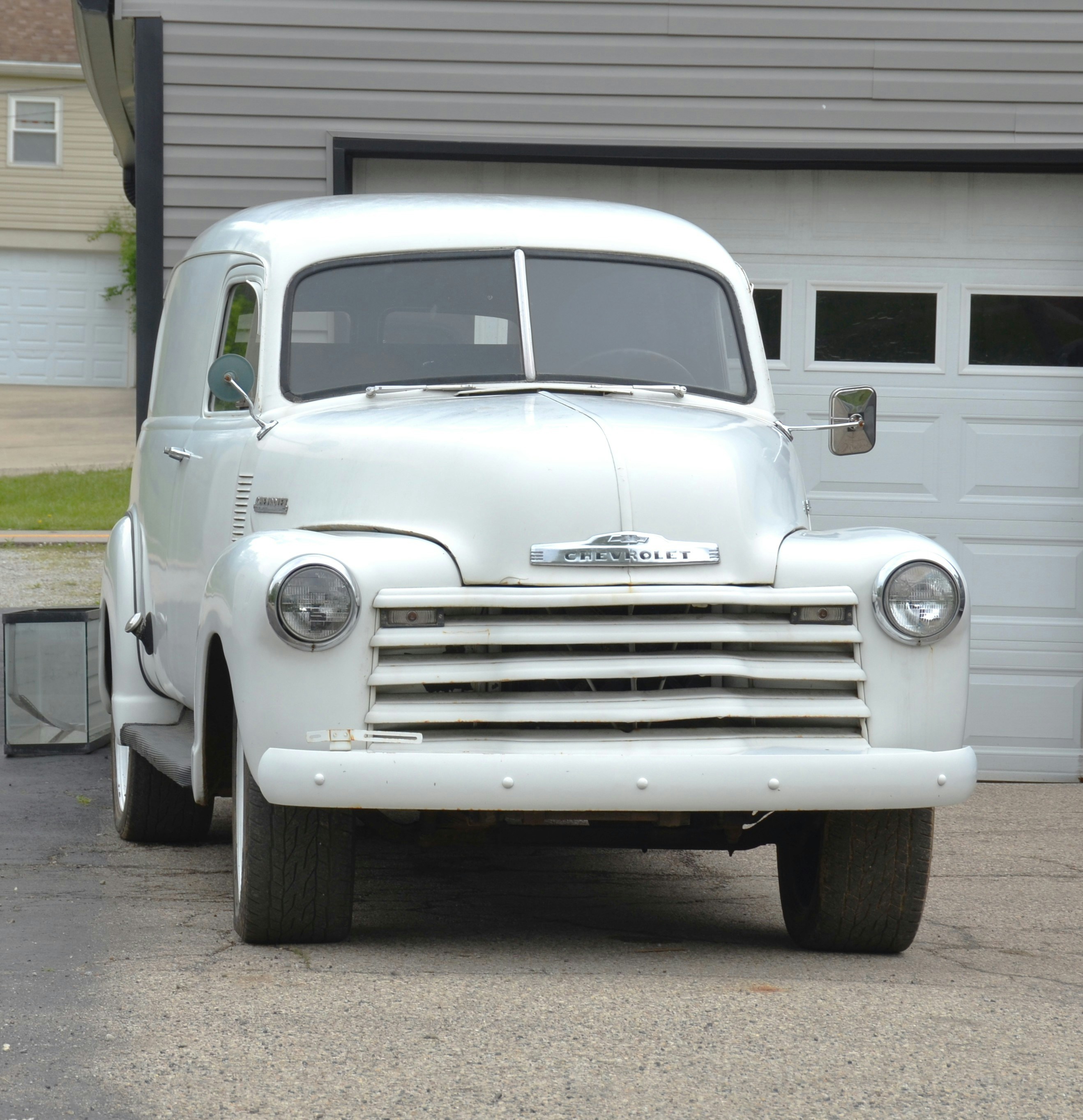 Un fourgon Chevrolet blanc vintage était garé dehors.