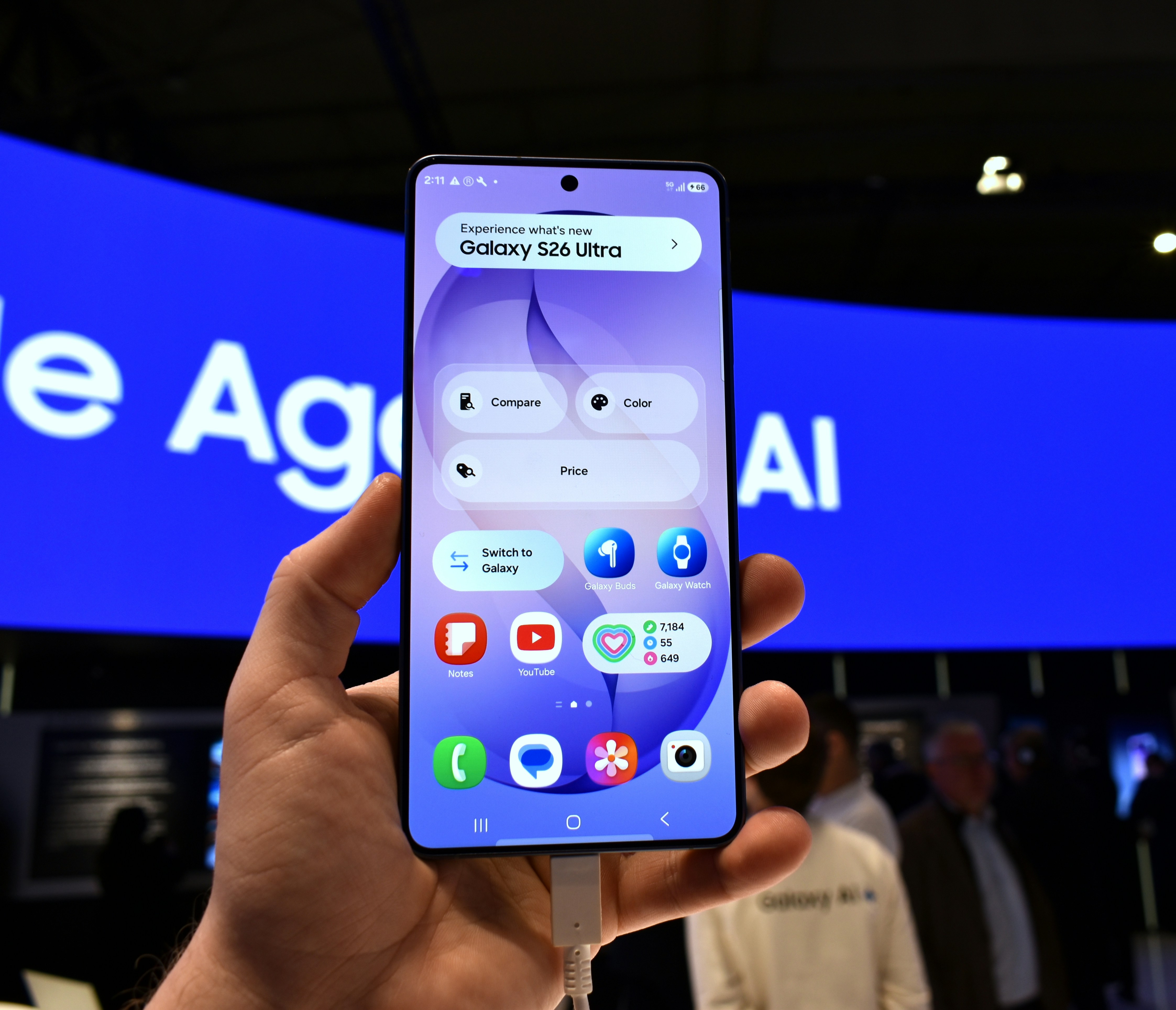 Hand holding a smartphone displaying a colorful user interface