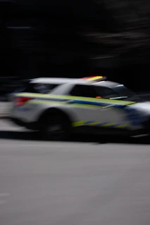 A police car with flashing lights driving fast.