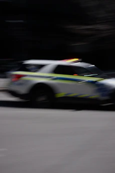 A police car with flashing lights driving fast.