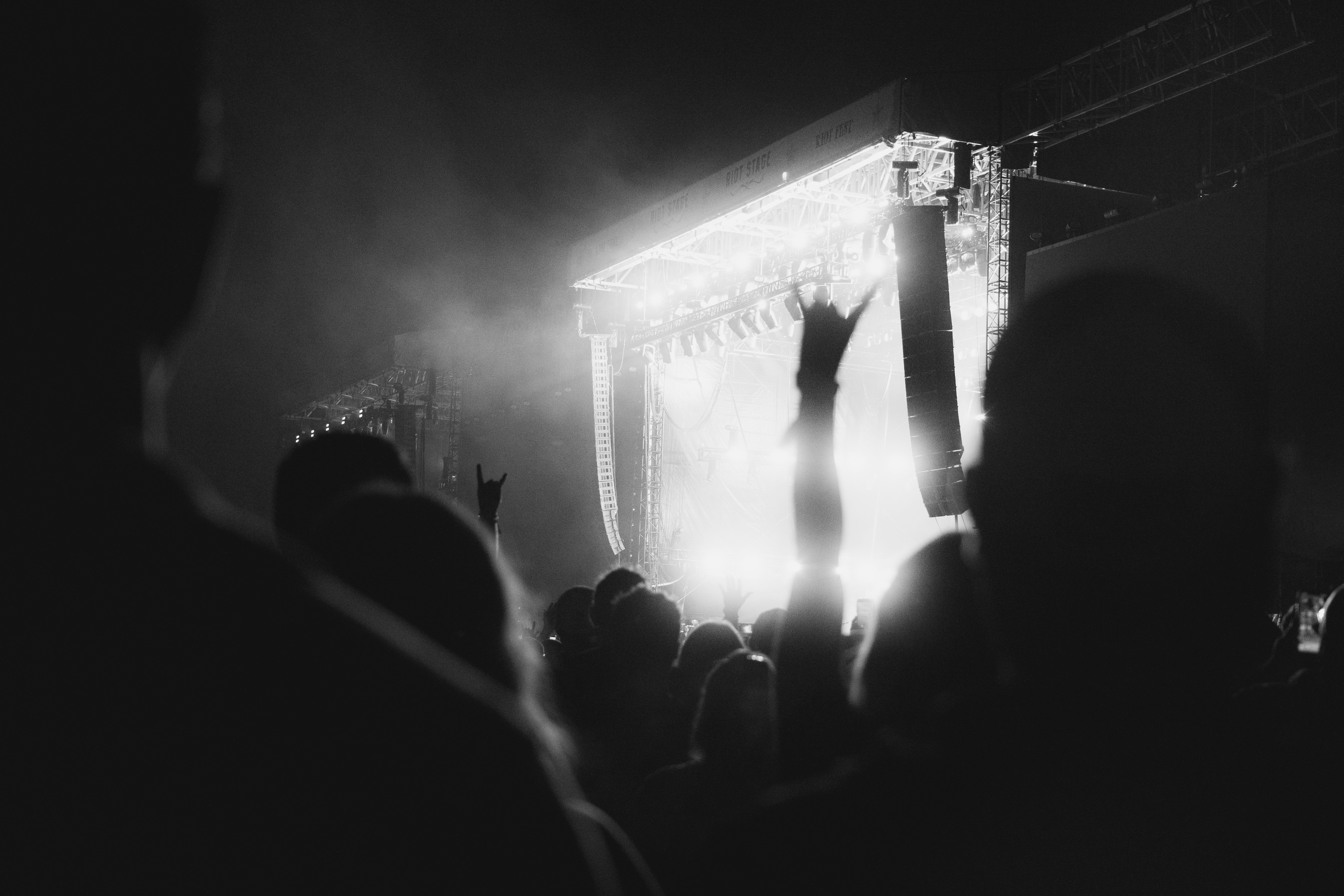 Crowd with hands up at a bright concert stage