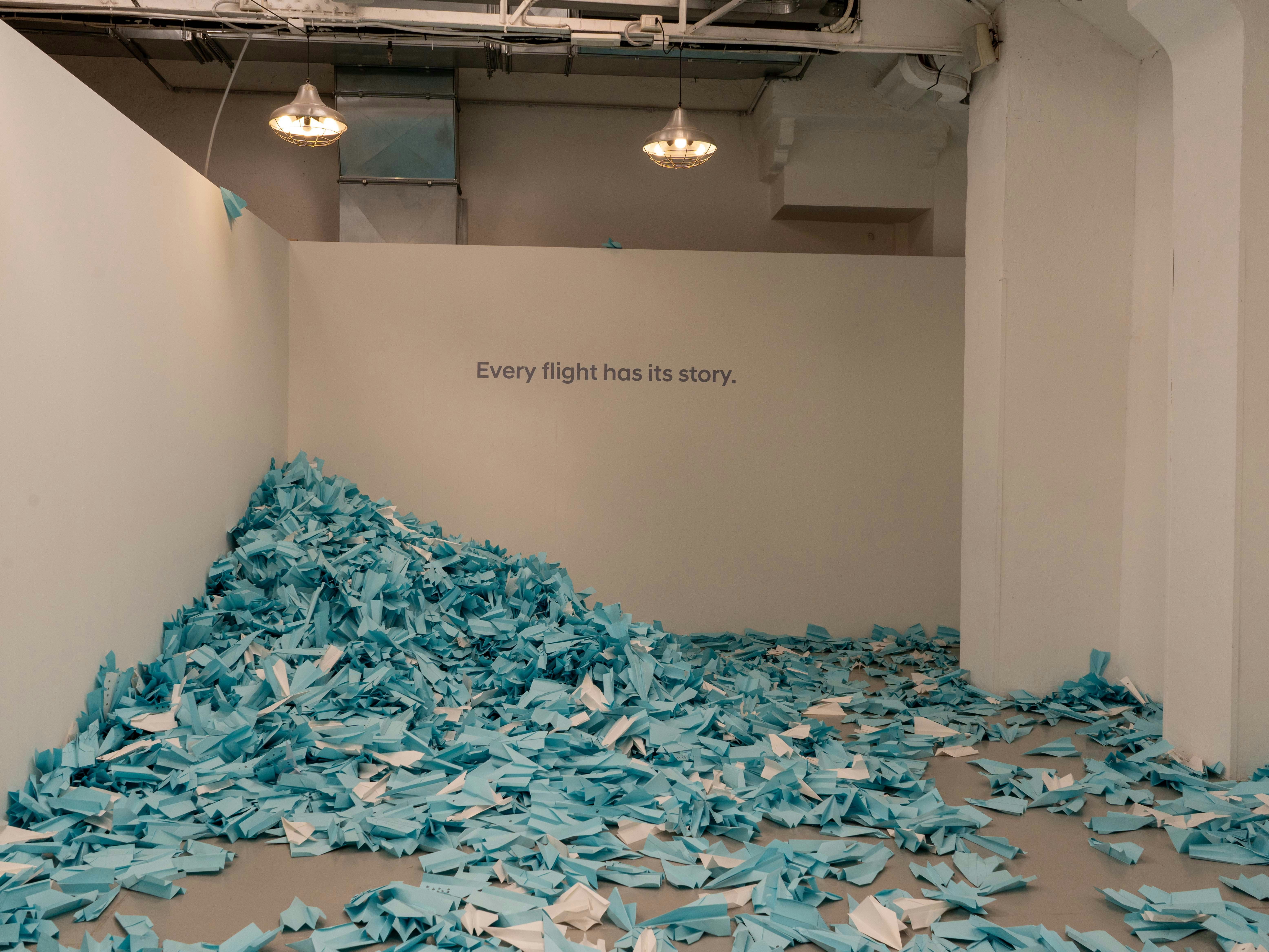 Uma grande pilha de pedaços de papel azul no chão.