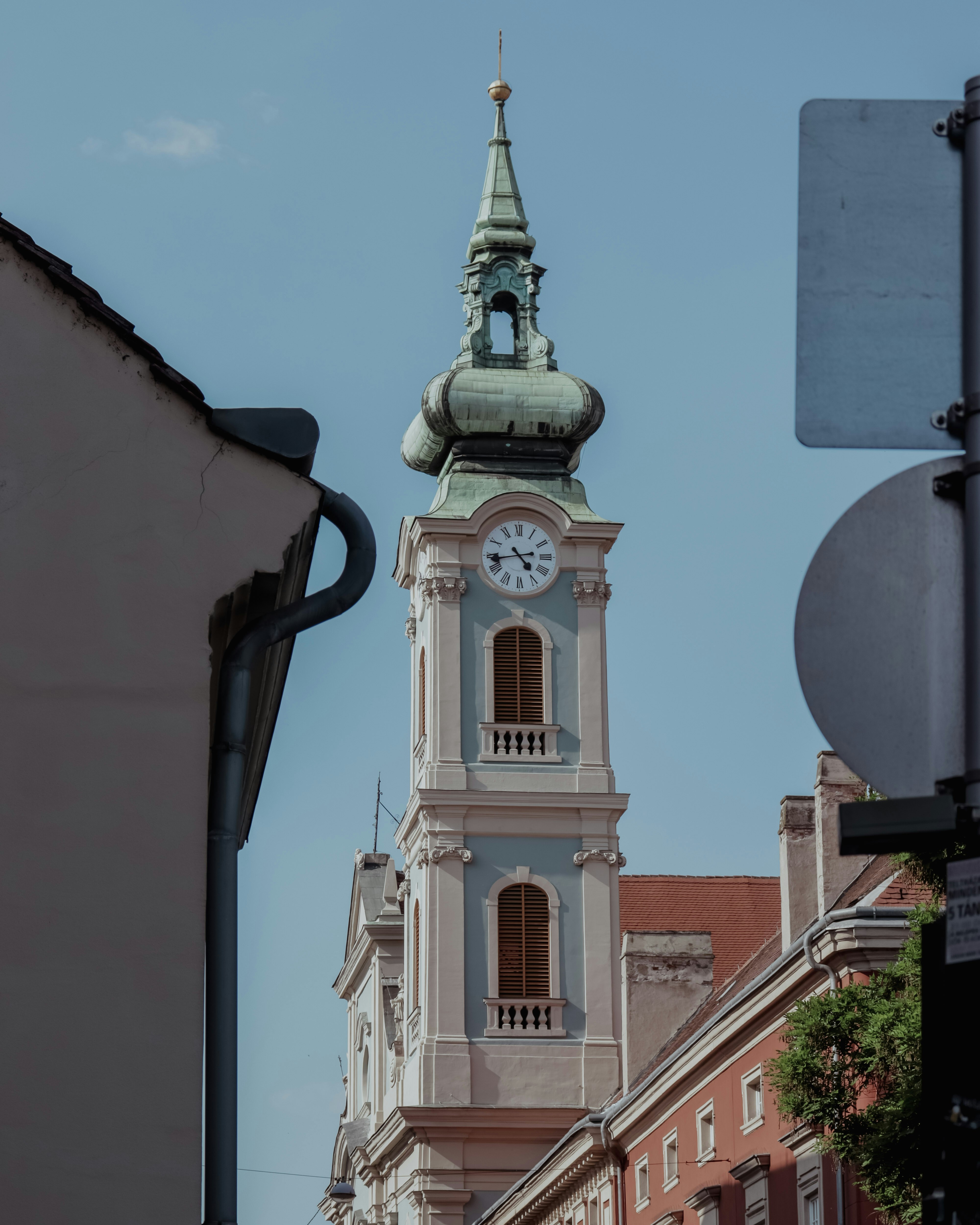 Ein Kirchturm mit einer Uhr vor blauem Himmel.