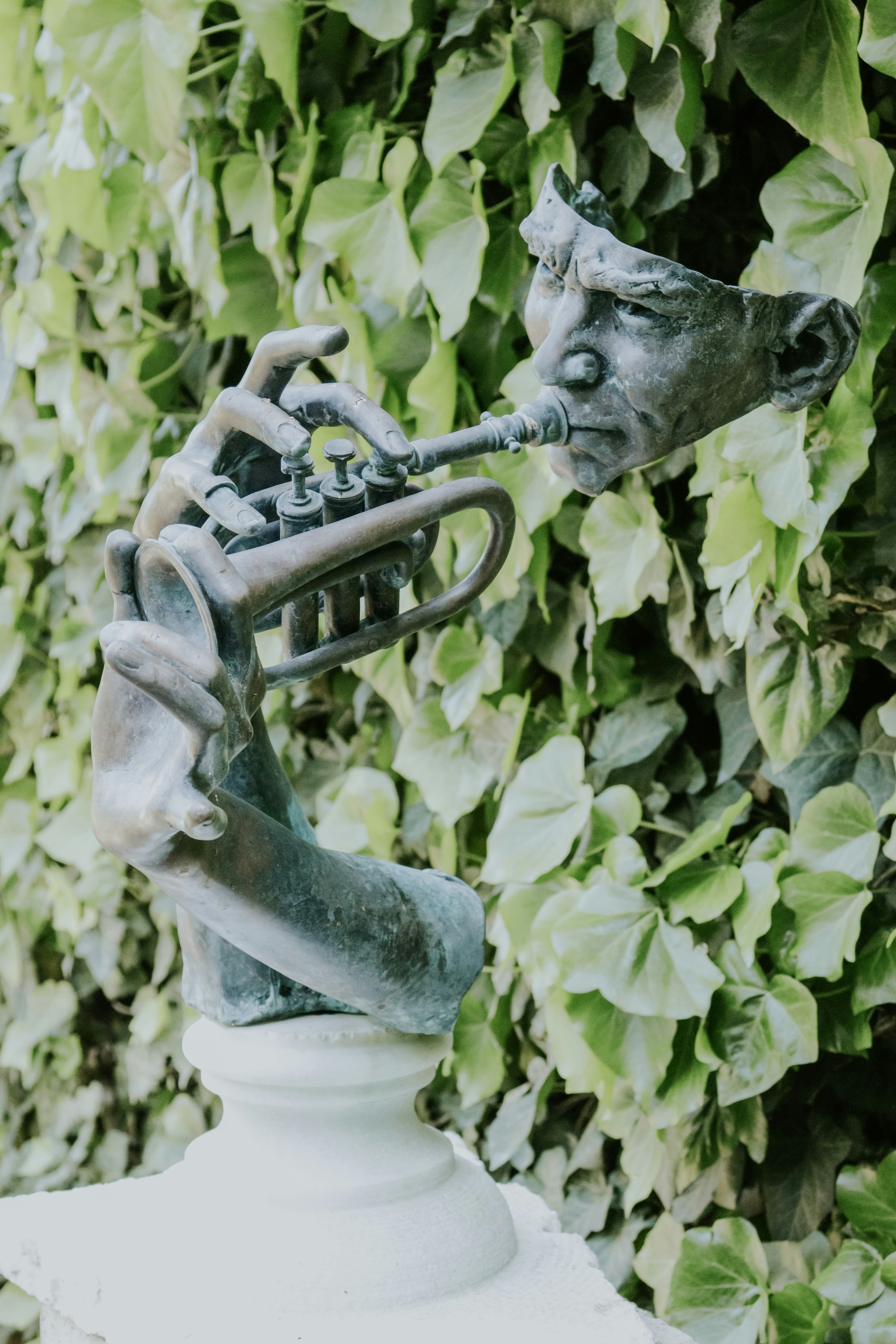 Bronzeskulptur einer verspielten Figur, die Trompete spielt
