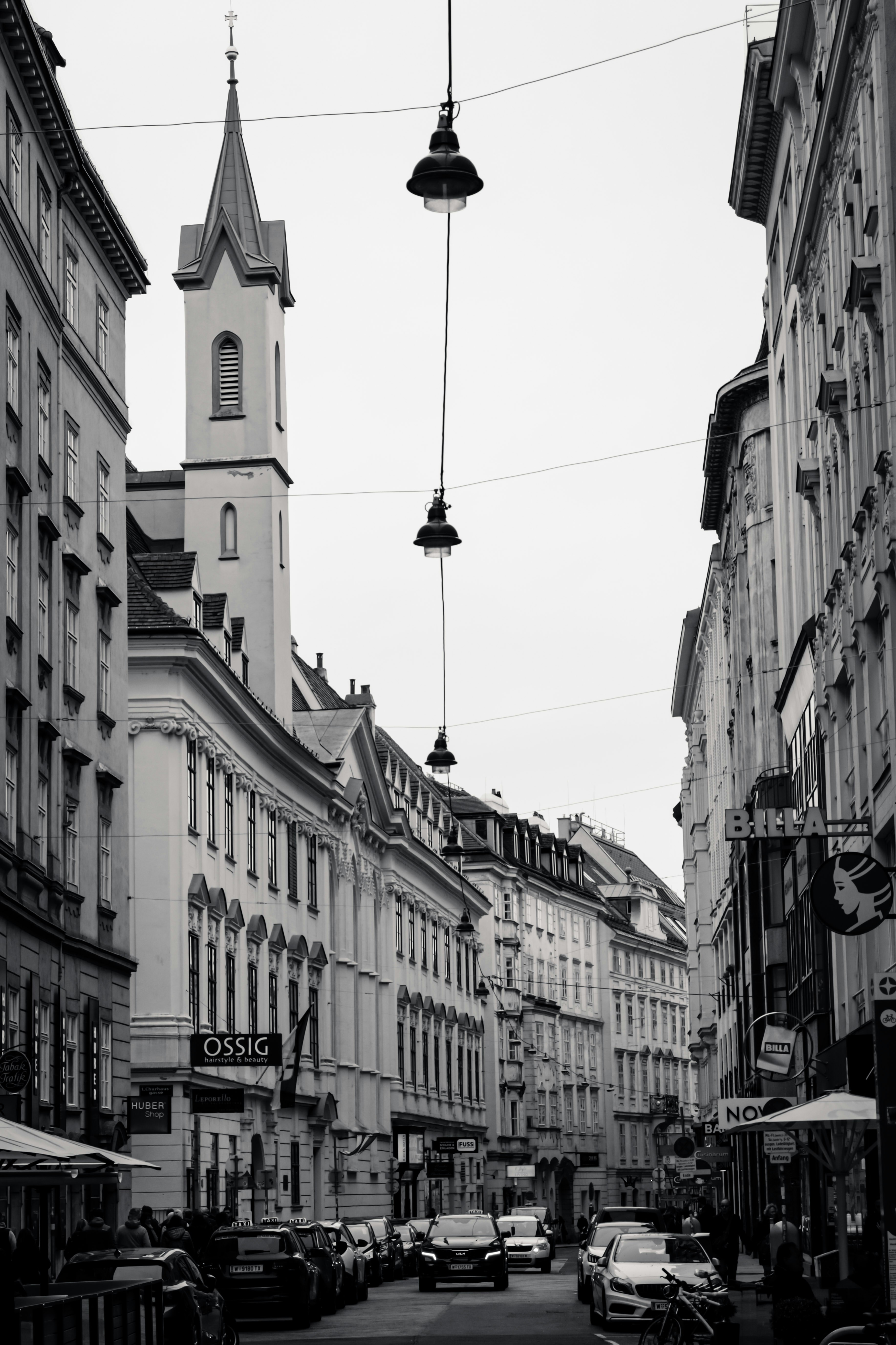 Straßenansicht mit Gebäuden und Autos in Schwarzweiß.