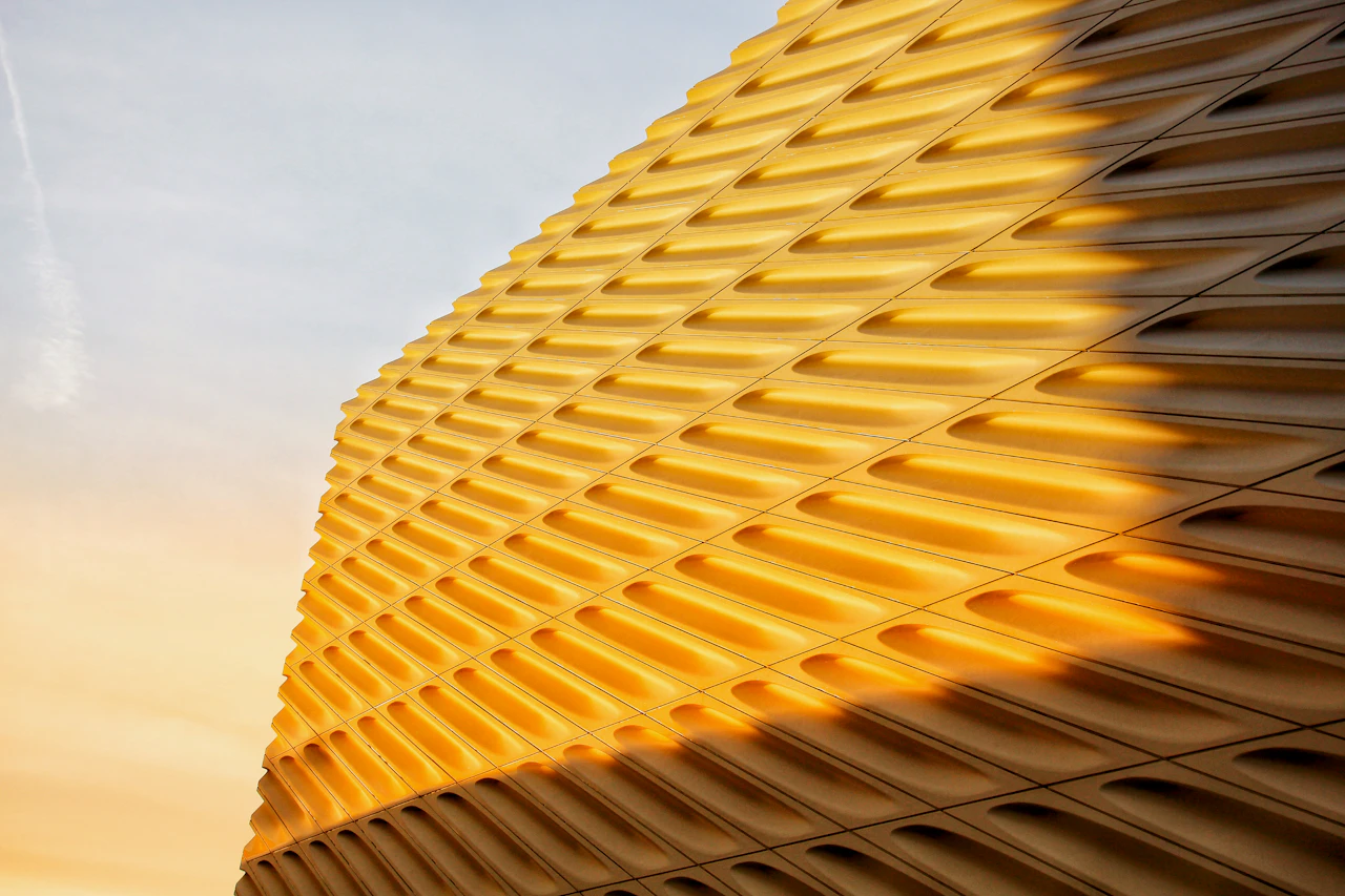 A sunlit undulating golden building facade