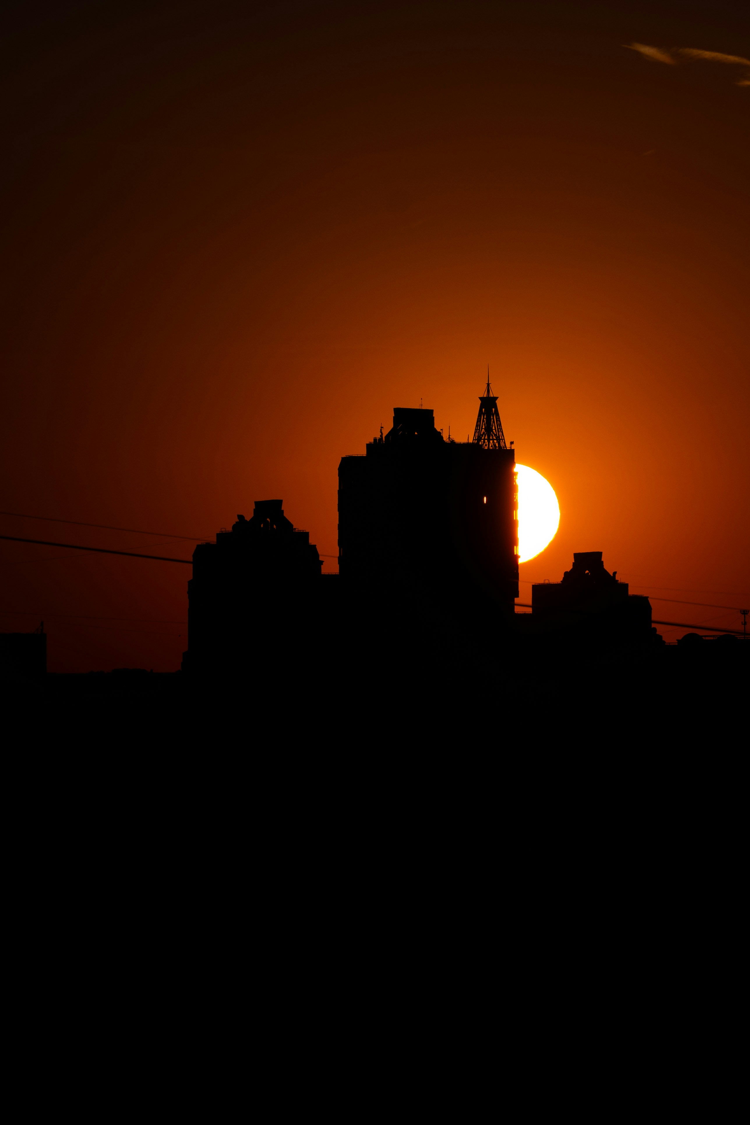 Silhouette of buildings against a vibrant sunset.