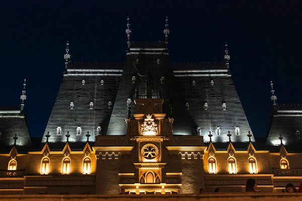 Ornate building illuminated at night with dark sky — Iași, Romania