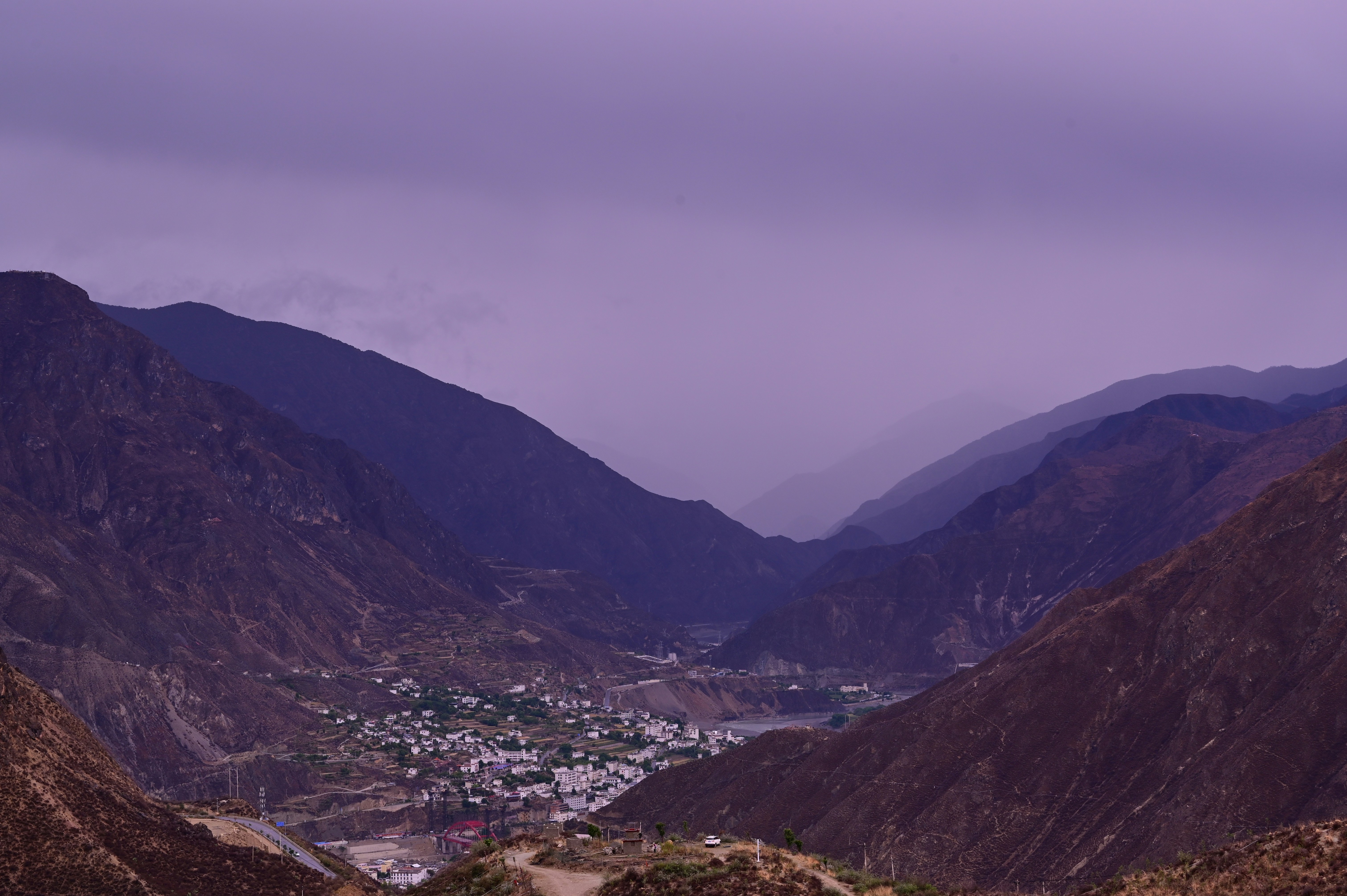 A remote village nestled in a vast mountain valley.