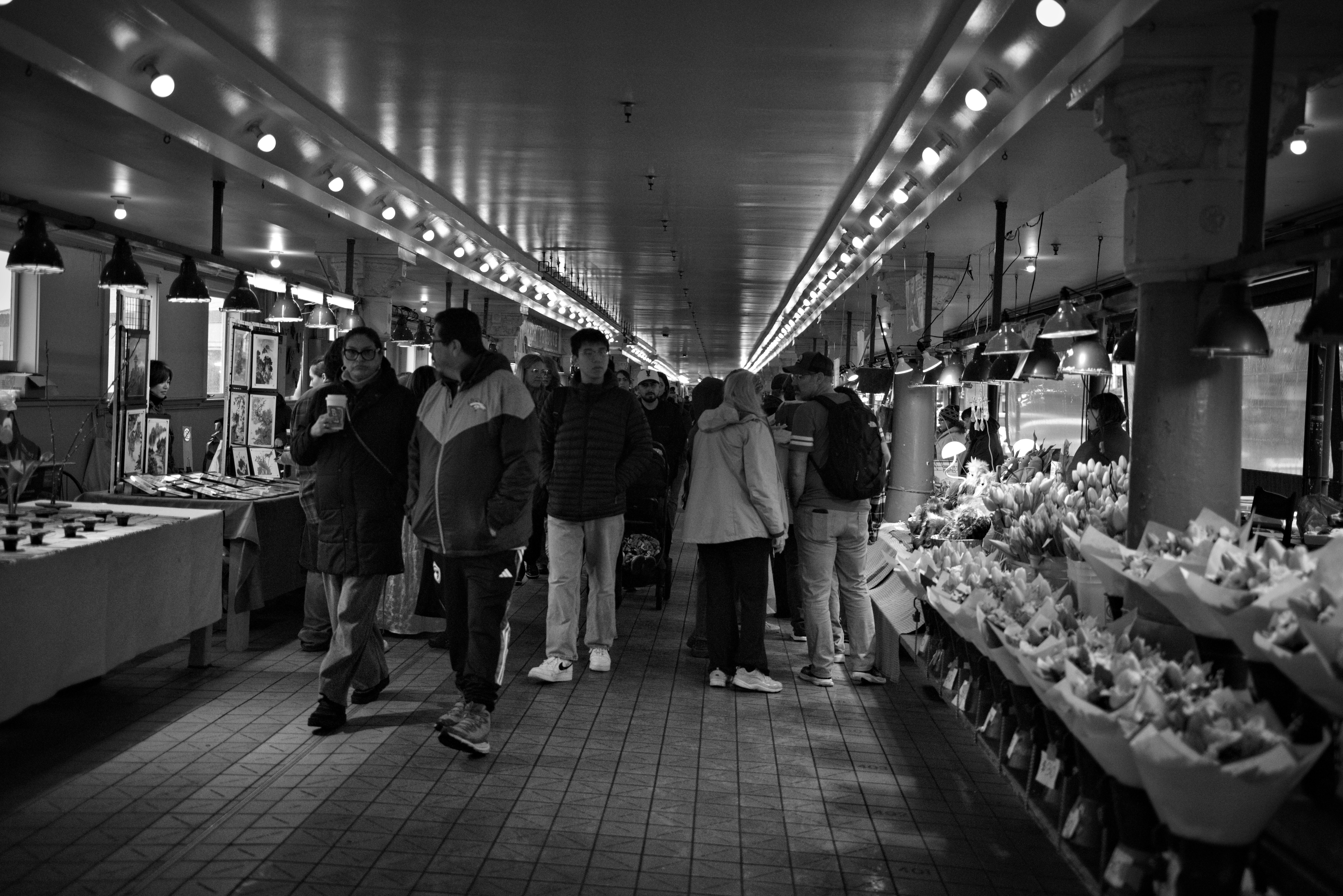 Persone che camminano attraverso una sala del mercato affollata.