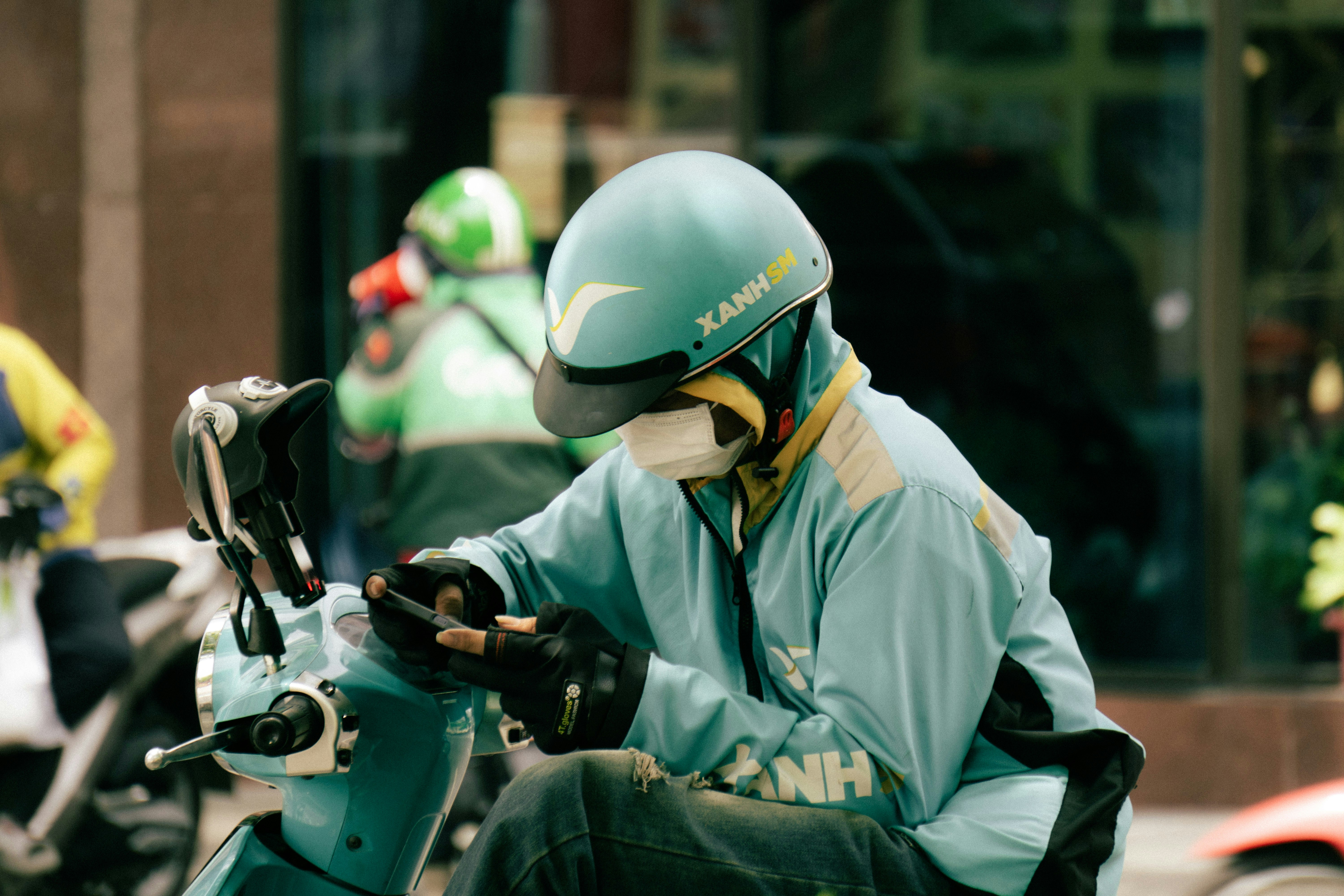 Delivery person in a helmet using a smartphone