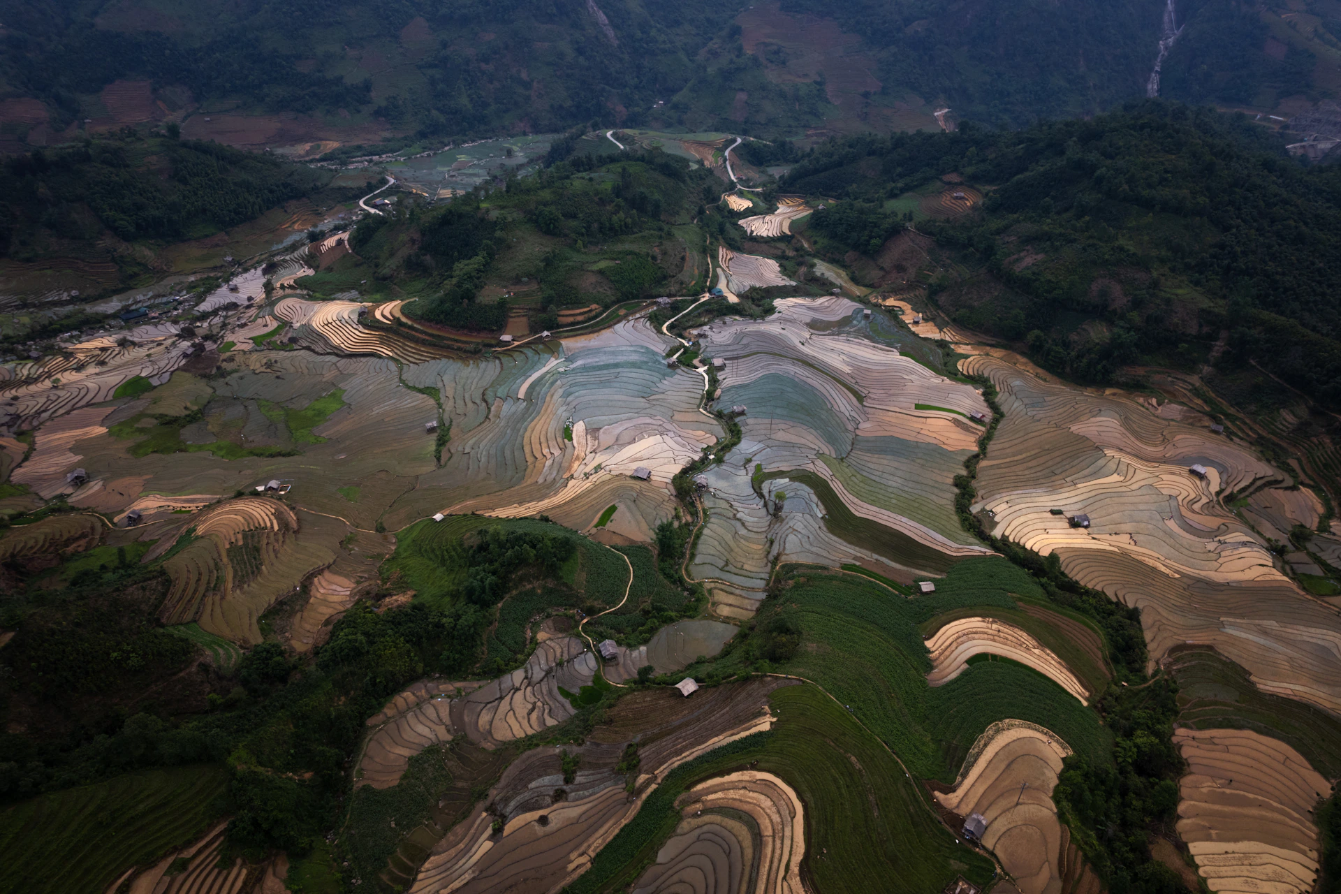 Aerial view of flooded rice terraces in a valley