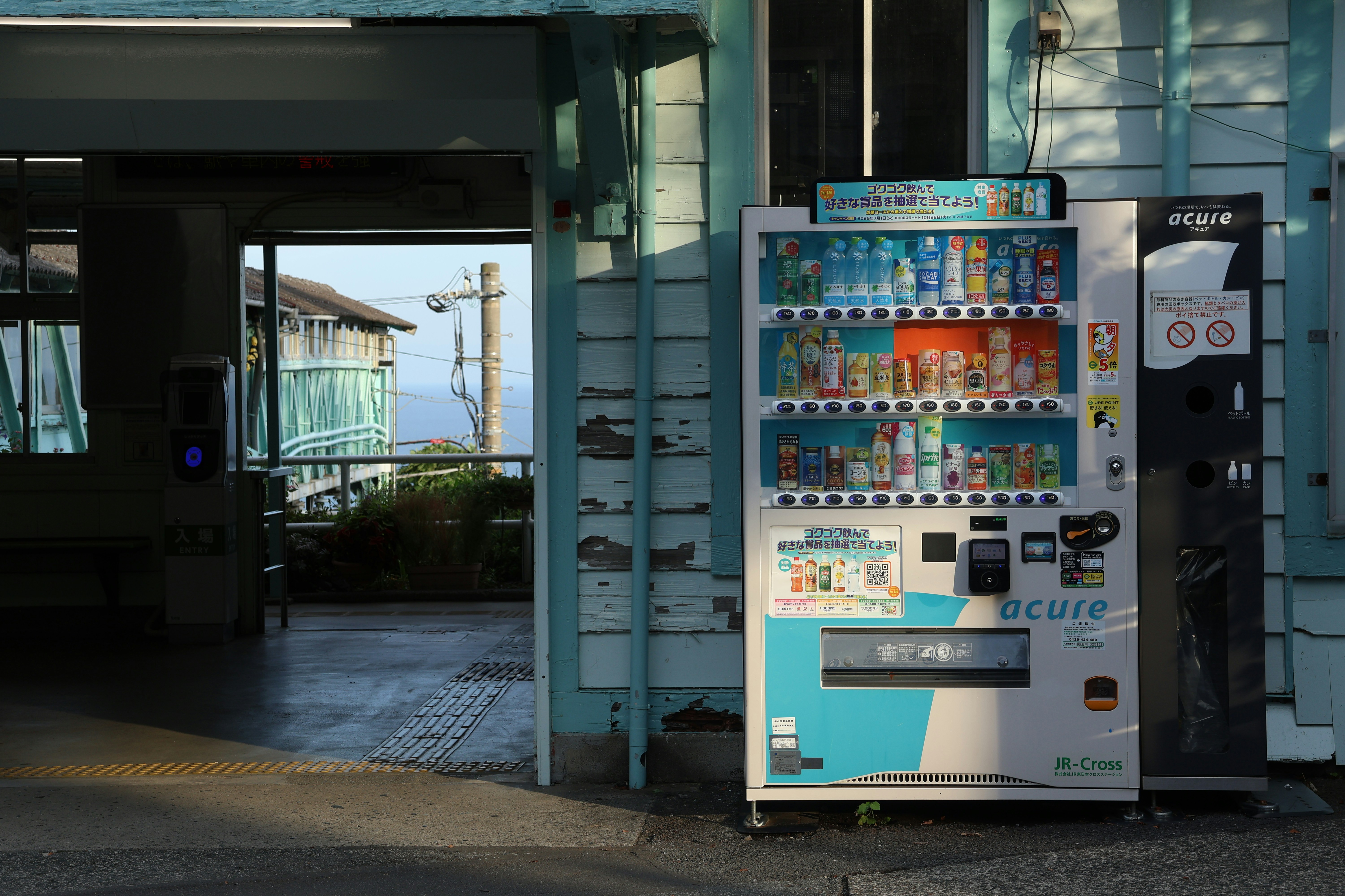 Vending machines outside a building with ocean view.