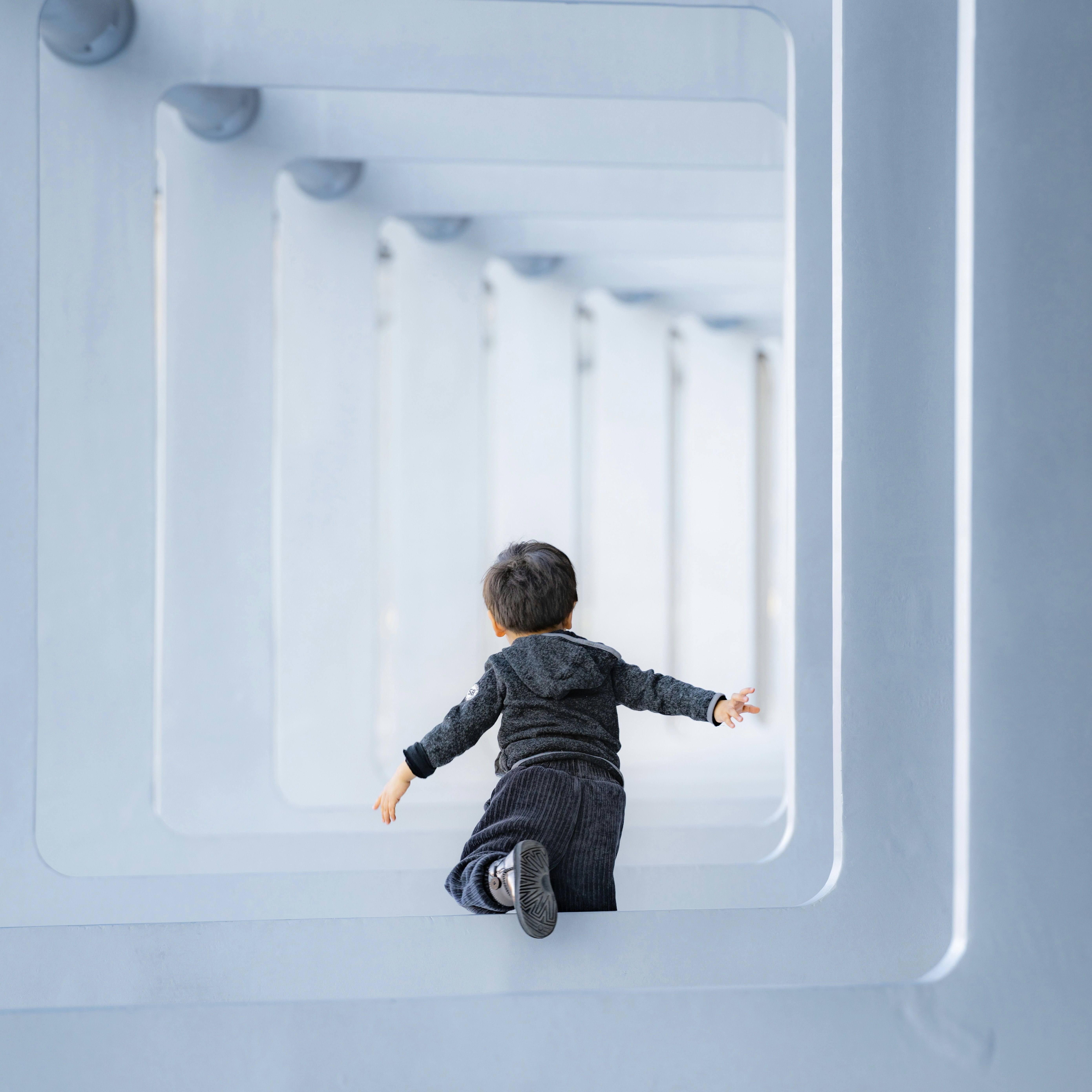 Un niño pequeño gatea por un camino moderno y luminoso.