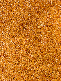 A pile of small, golden-brown seeds