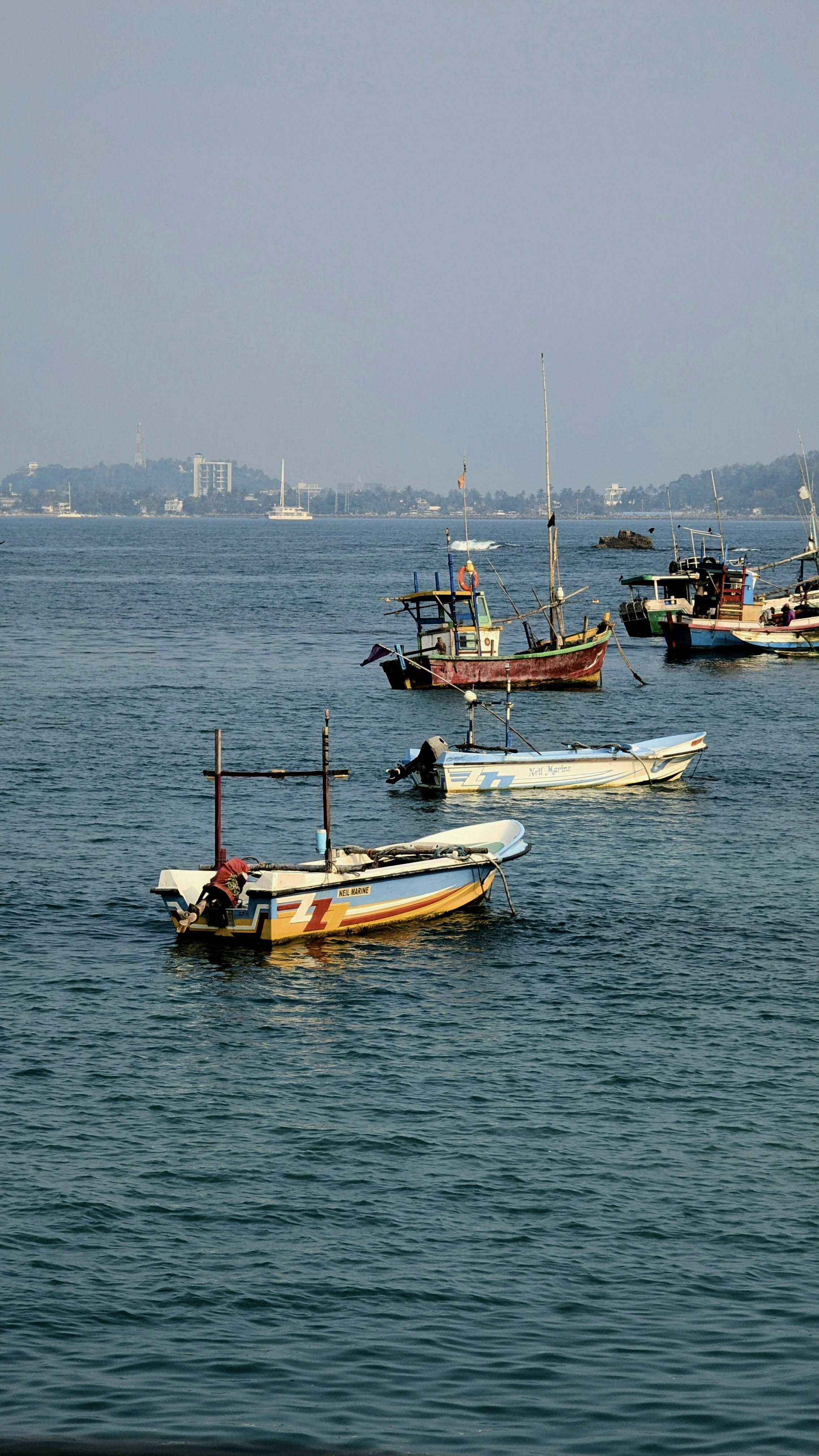 Diverse barche galleggiano sull'acqua blu dell'oceano.