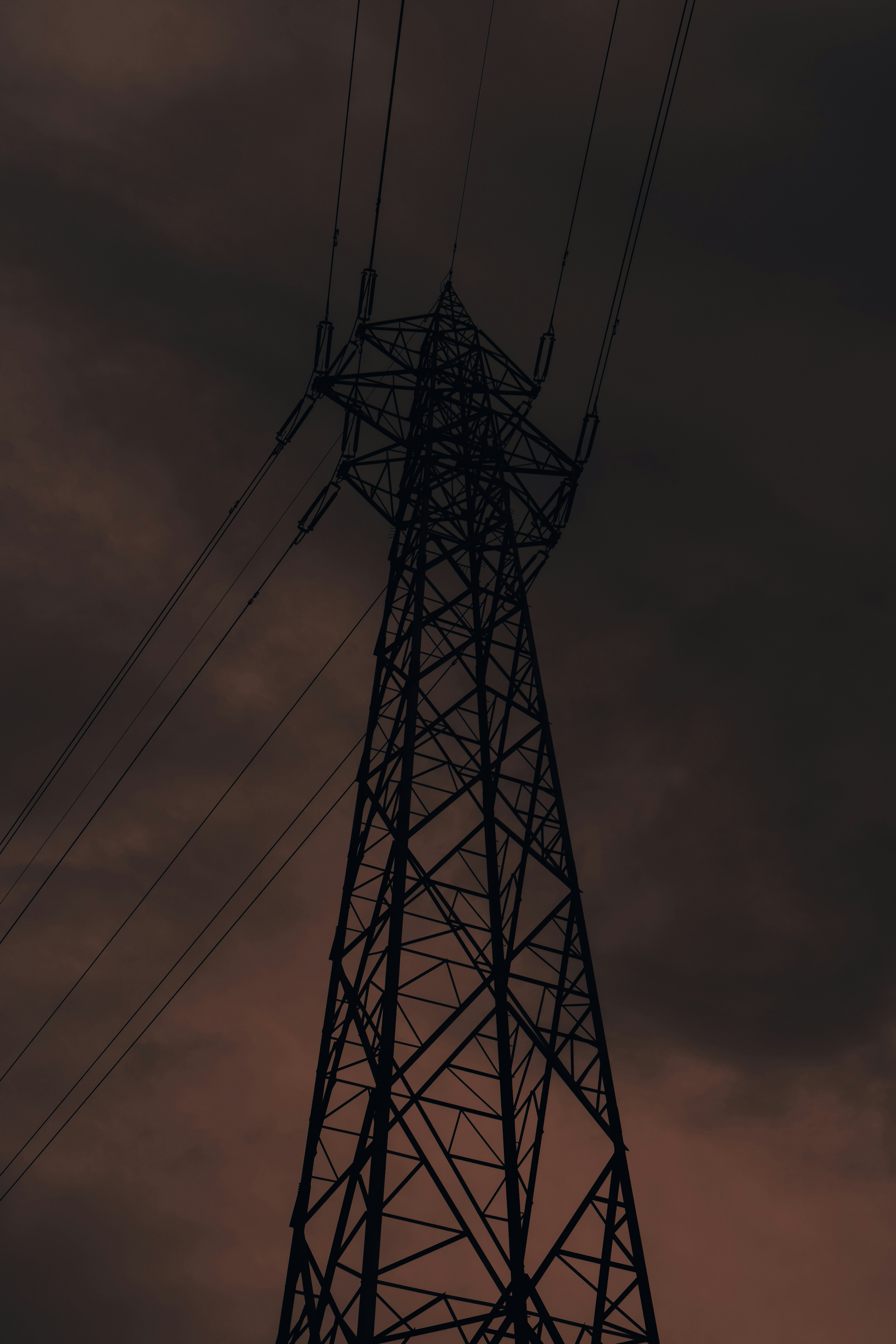 Una alta torre de línea eléctrica contra un cielo oscuro