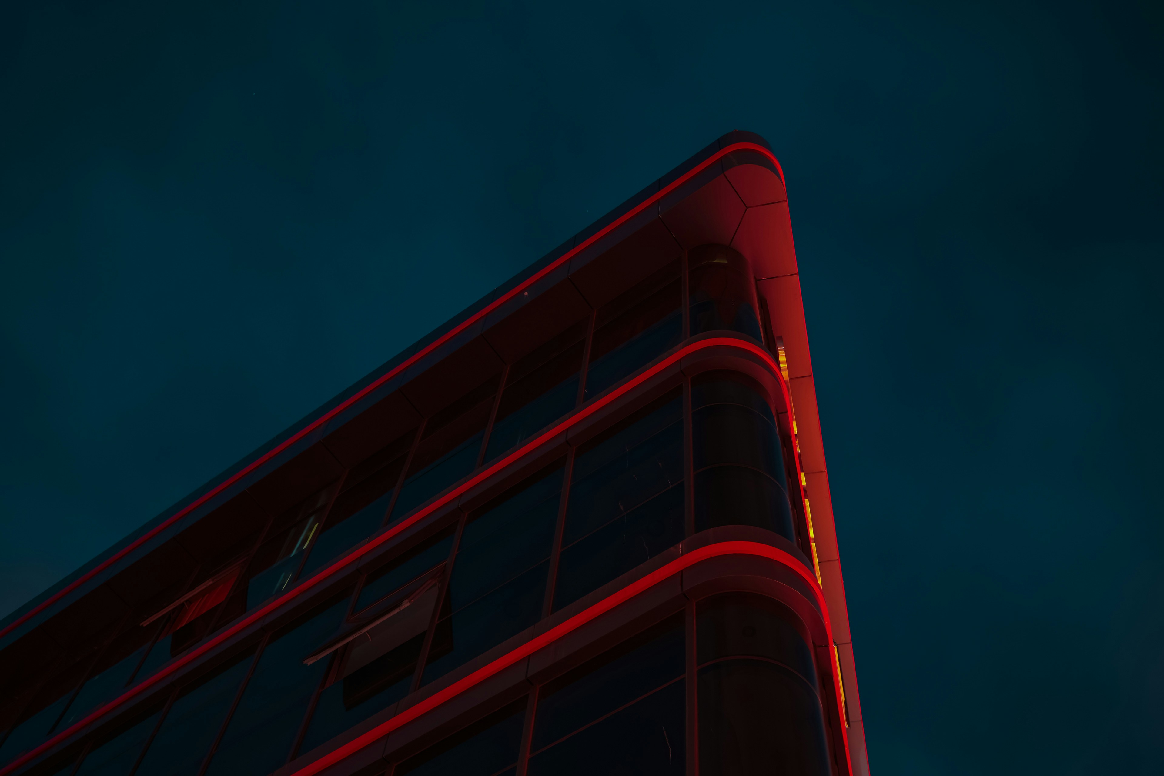 Edificio moderno con luces de neón rojas al anochecer