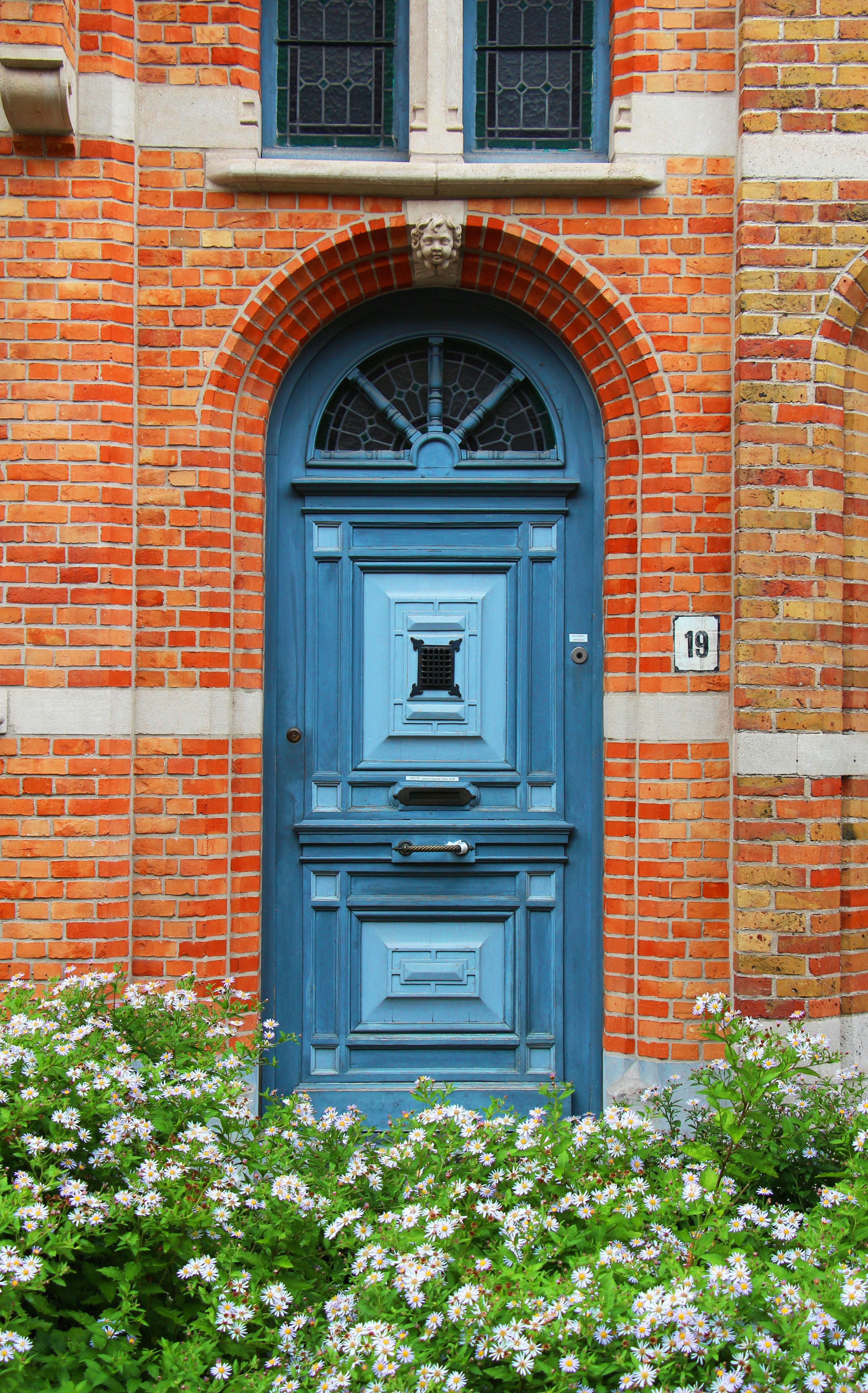 Porte bleue ornée avec des fleurs blanches devant