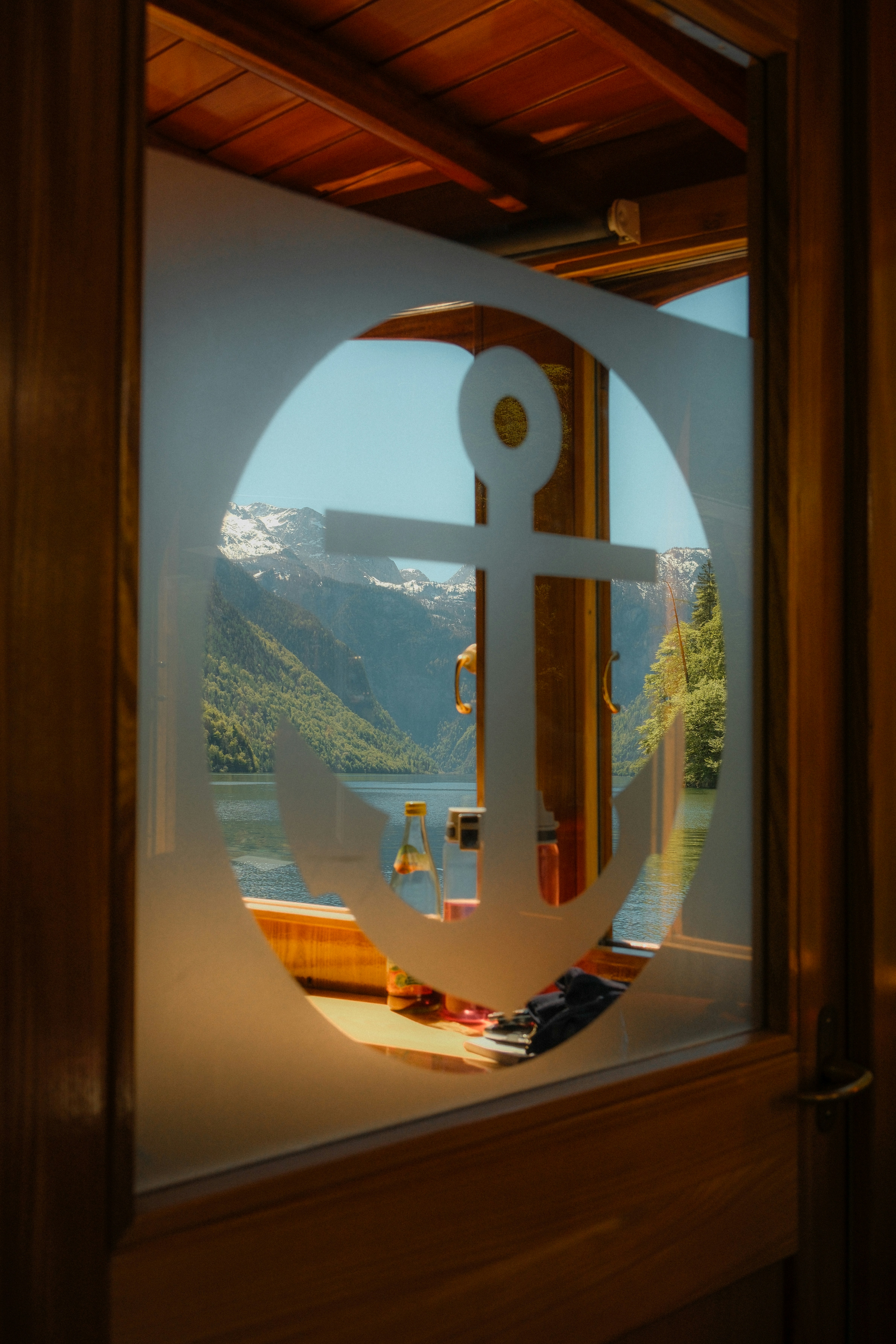 Anchor etched on window with mountain lake view