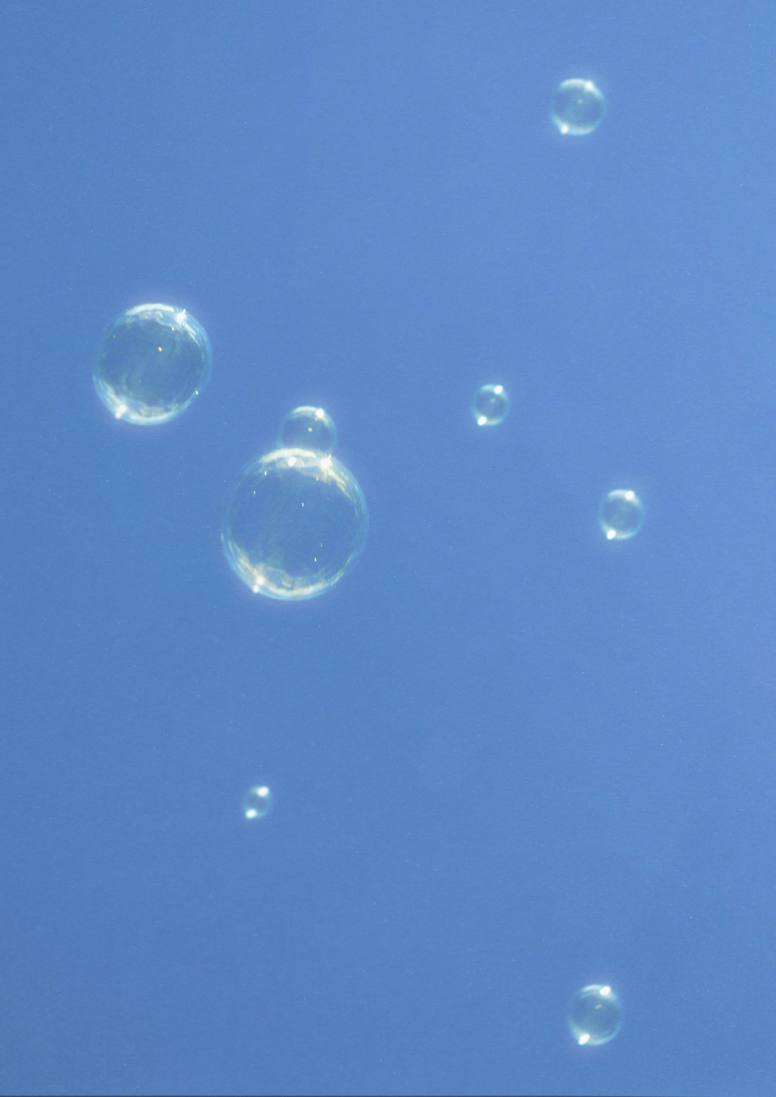 Bubbles floating against a clear blue sky