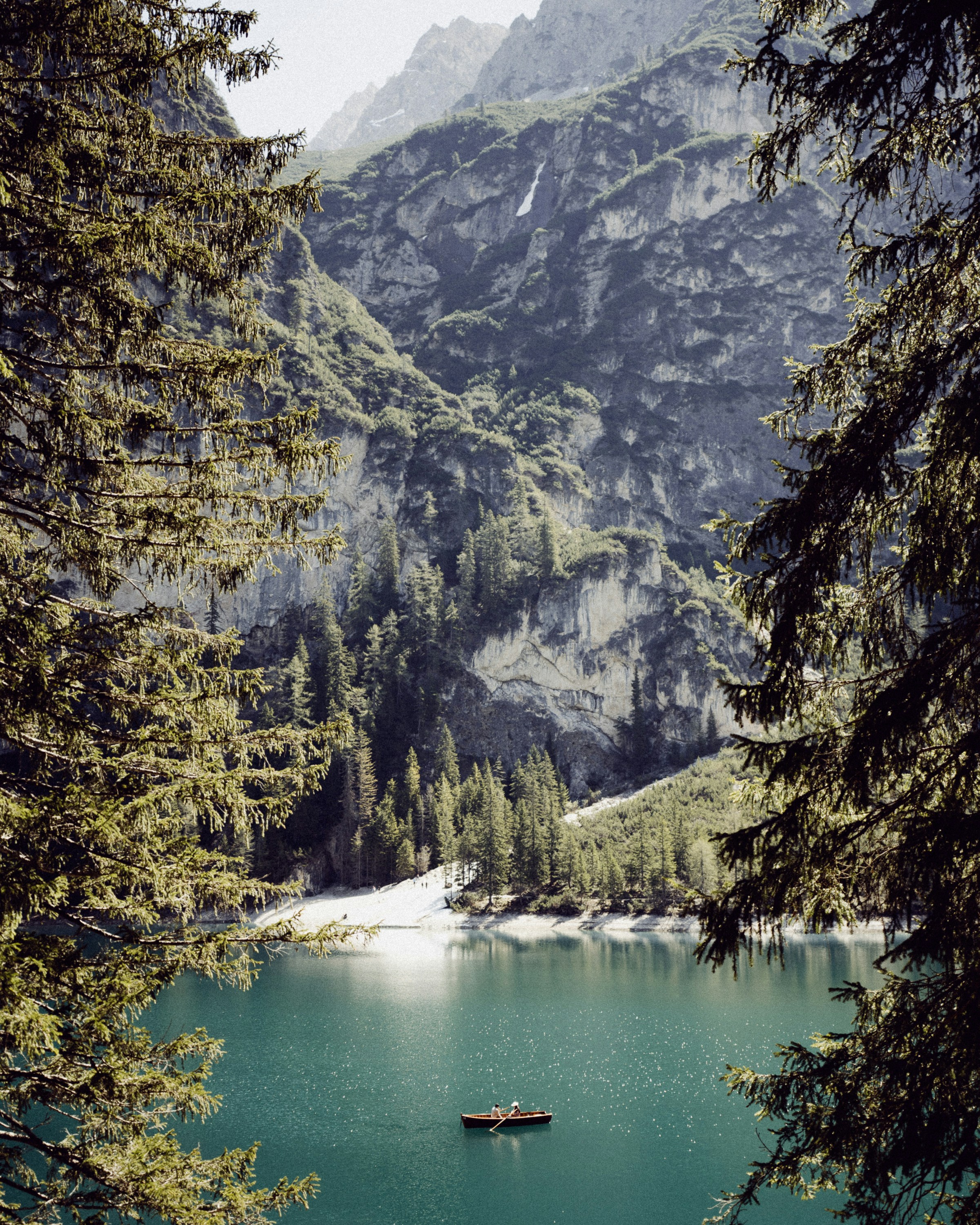 Un lago sereno rodeado de altas montañas y árboles.