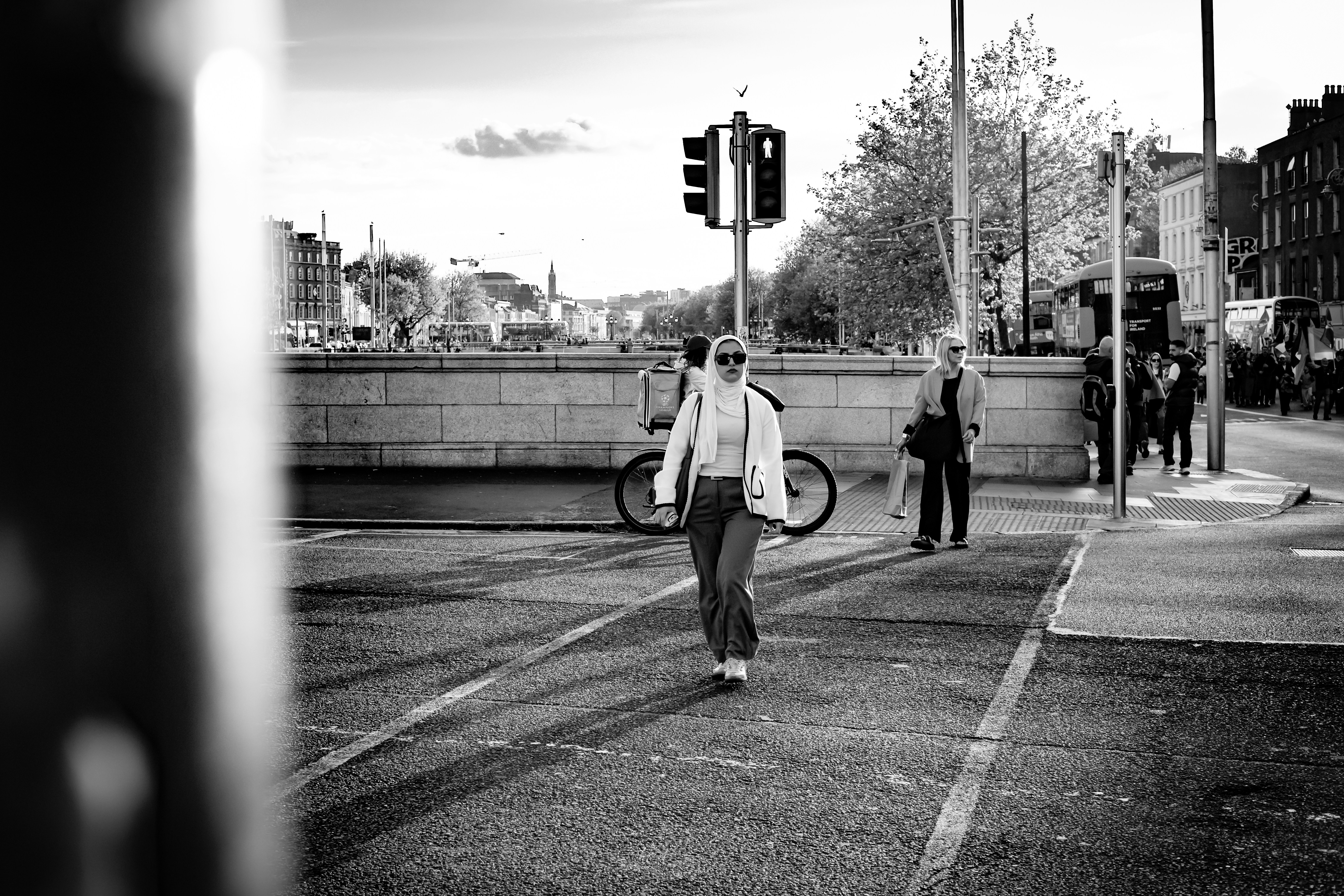 Gente cruzando una calle de la ciudad al atardecer.