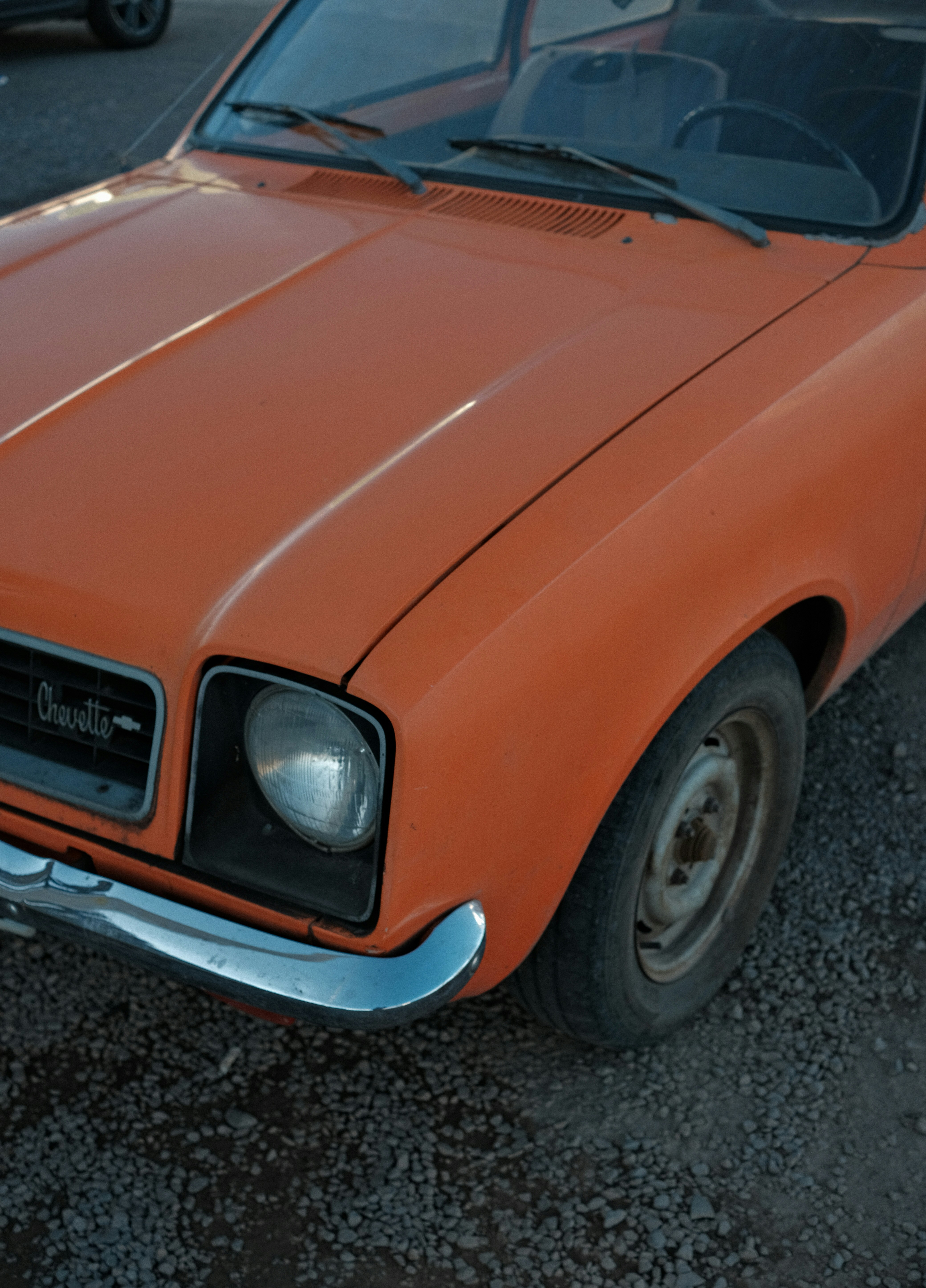 Nahaufnahme des vorderen Kotflügels eines orangefarbenen Vintage-Autos.