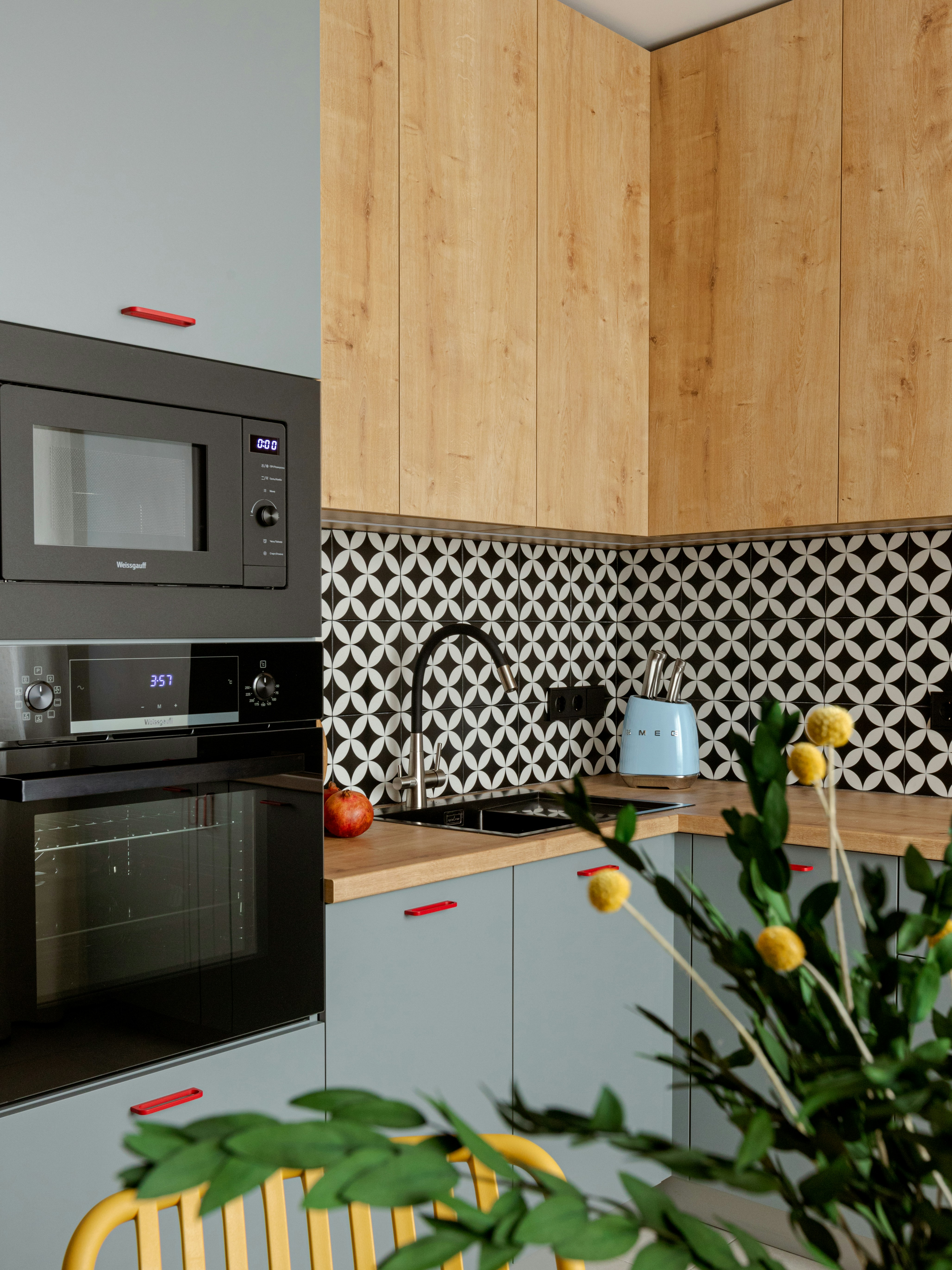 Modern kitchen with light wood cabinets and gray accents.