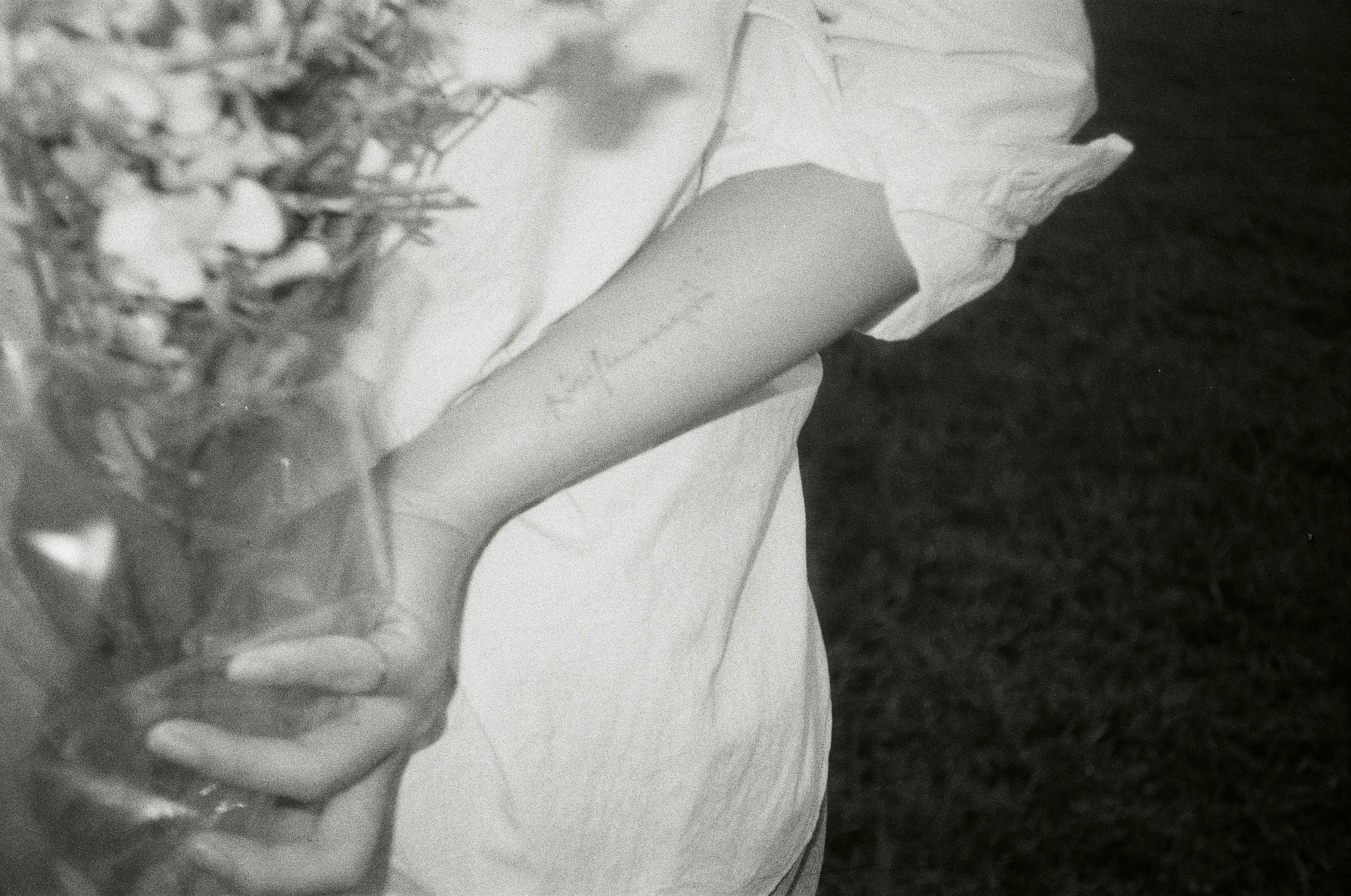 Person holding a bouquet of flowers behind their back